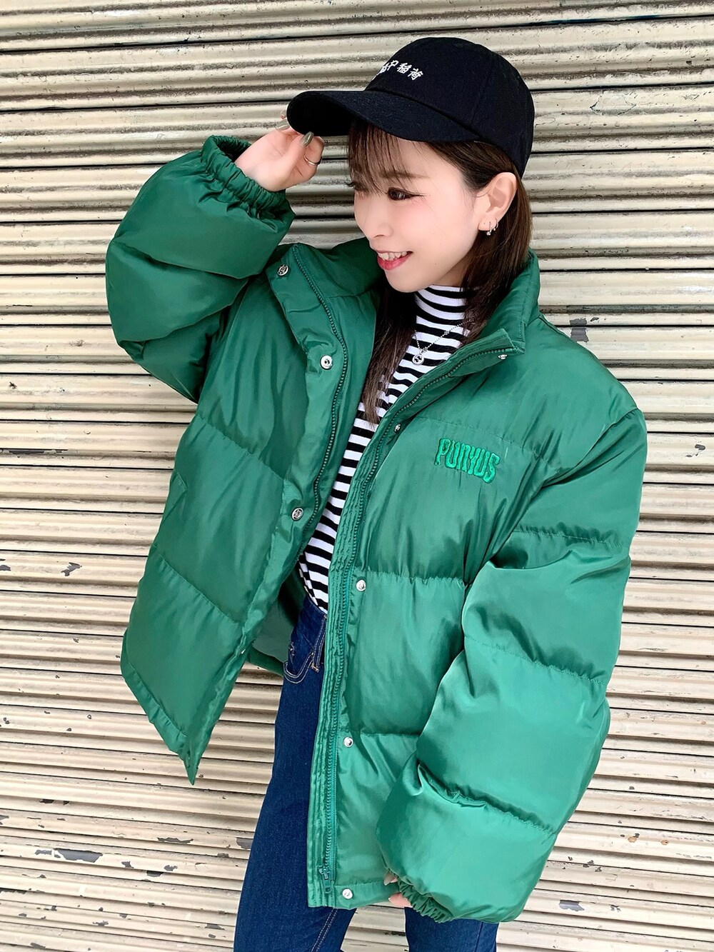 ブラック系のスニーカー、ホワイト系のTシャツ/カットソー、ブルー系のデニムパンツを着用したレディースの秋コーディネートの2枚目の写真