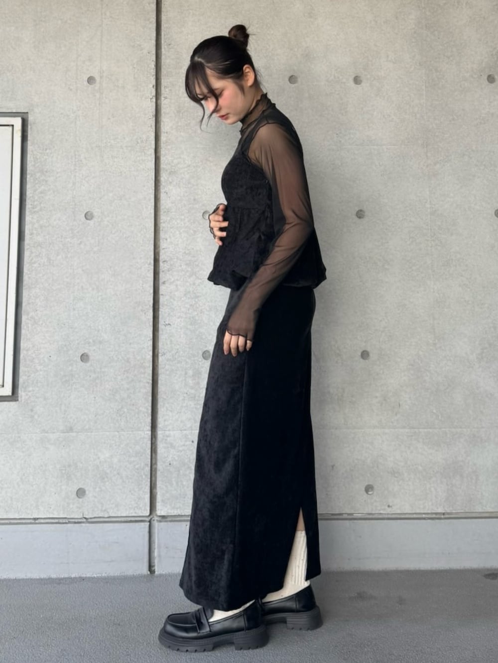 ブラック系のスカート、ブラック系のTシャツ/カットソー、ブラック系のチュニックを着用したレディースの冬コーディネートの3枚目の写真