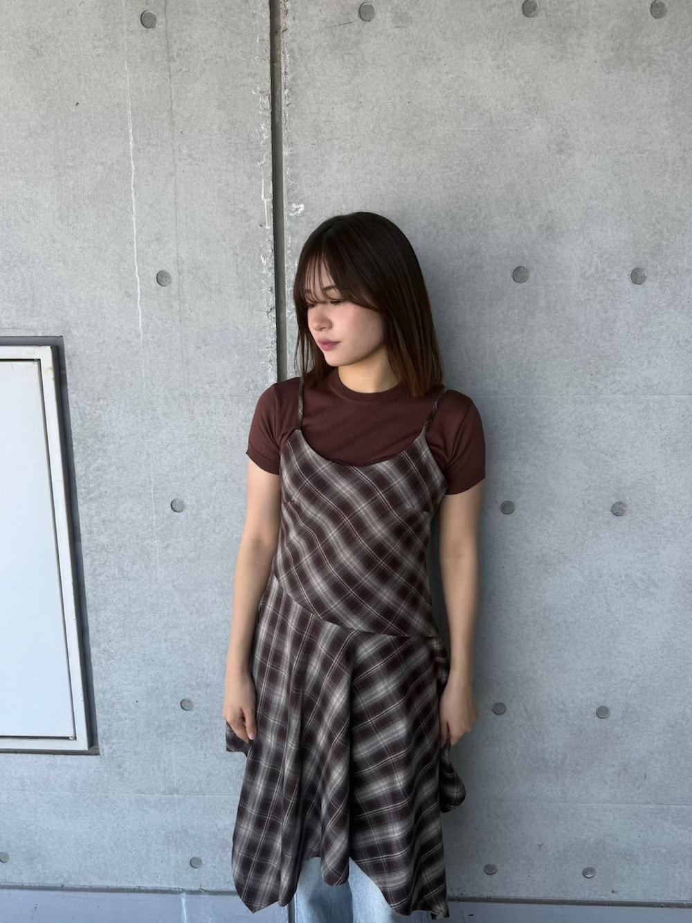 ブルー系のデニムパンツ、ブラウン系のワンピース、ブラウン系のニット/セーターを着用したレディースの春コーディネートの5枚目の写真
