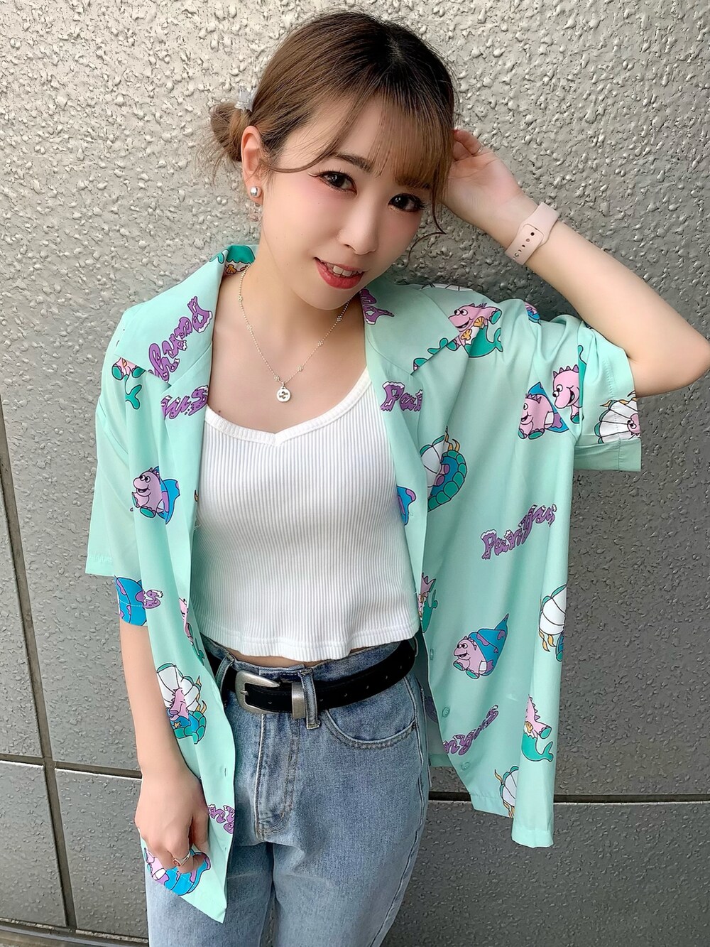 ブルー系のデニムパンツ、グリーン系のシャツ/ブラウス、ブラック系のサンダルを着用したレディースの夏コーディネートの2枚目の写真