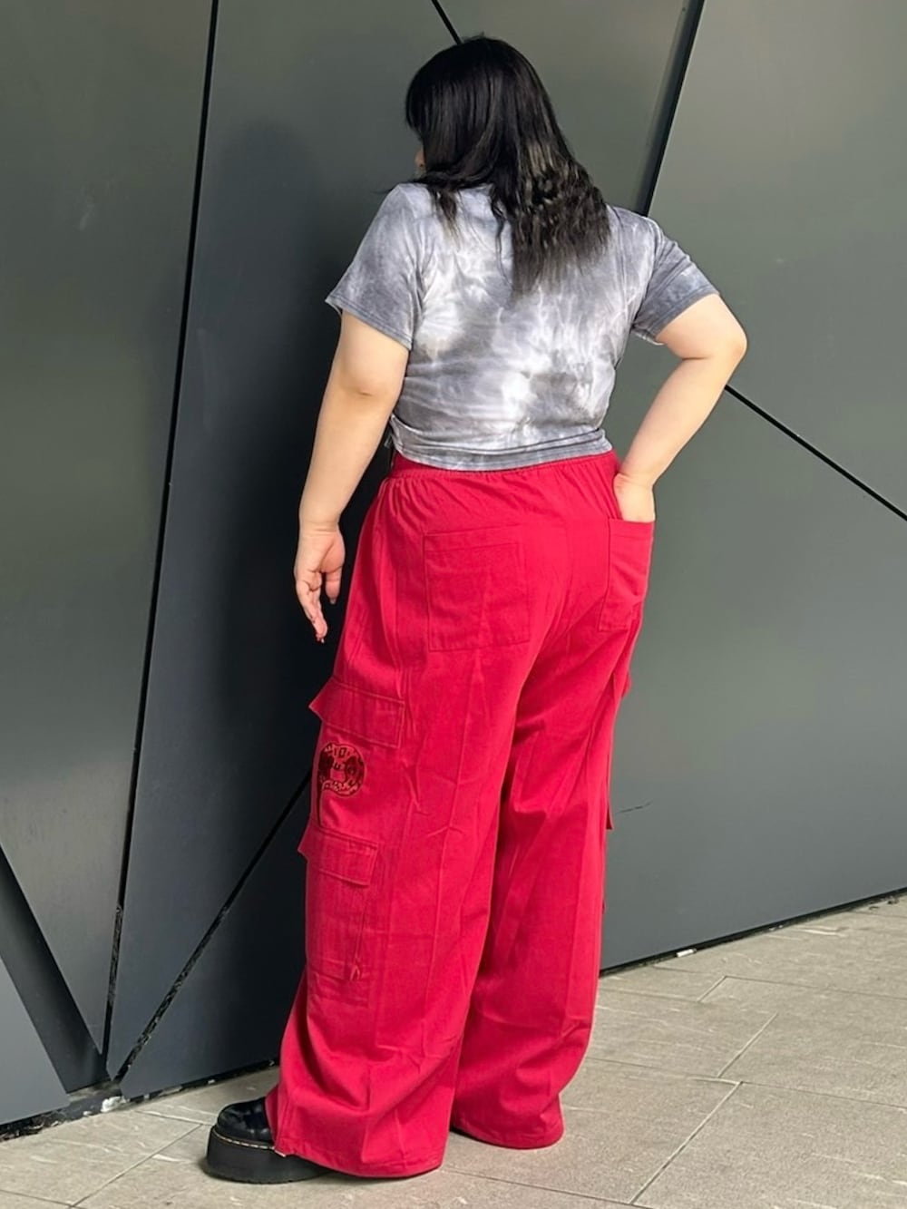 レッド系のカーゴパンツ、ブラック系のTシャツ/カットソーを着用したレディースの夏コーディネートの3枚目の写真