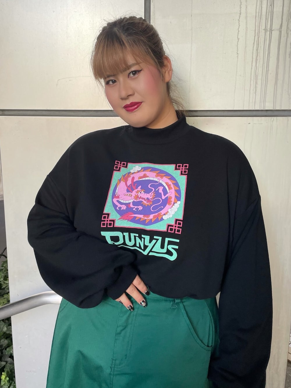 グリーン系のスカート、ブラック系のMA-1、ブラック系のスウェットを着用したレディースの秋コーディネートの3枚目の写真