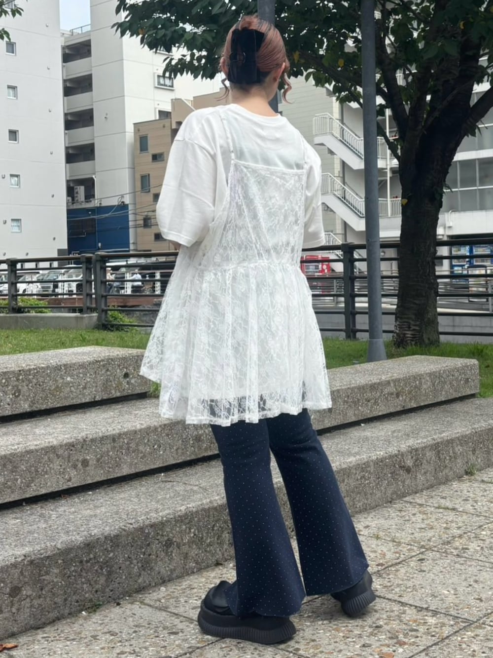 ホワイト系のチュニック、ホワイト系のTシャツ/カットソー、ブルー系のデニムパンツを着用したレディースの夏コーディネートの4枚目の写真