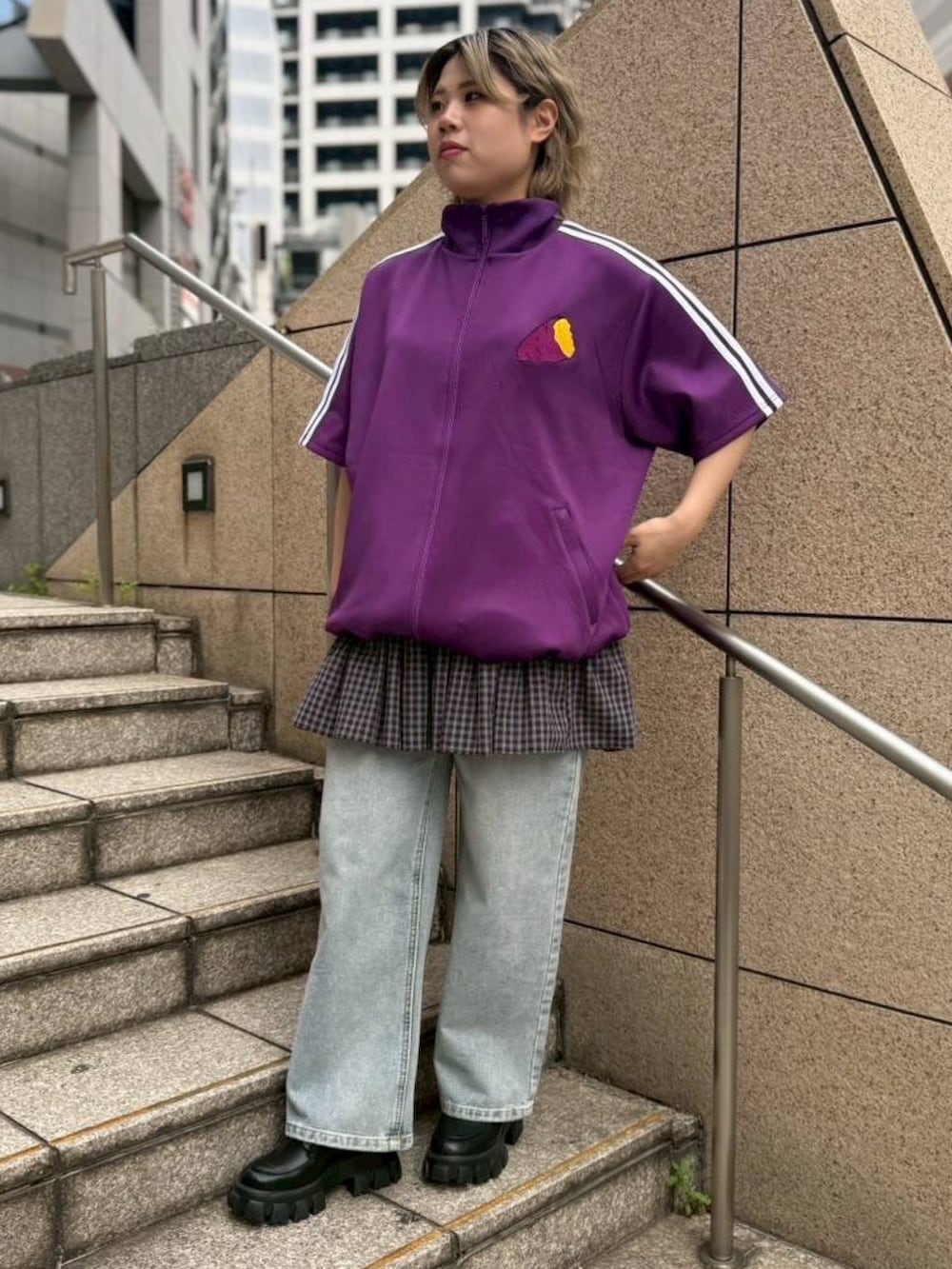 パープル系のジャージ、ブルー系のスカート、ブルー系のデニムパンツを着用したレディースの春コーディネートの3枚目の写真