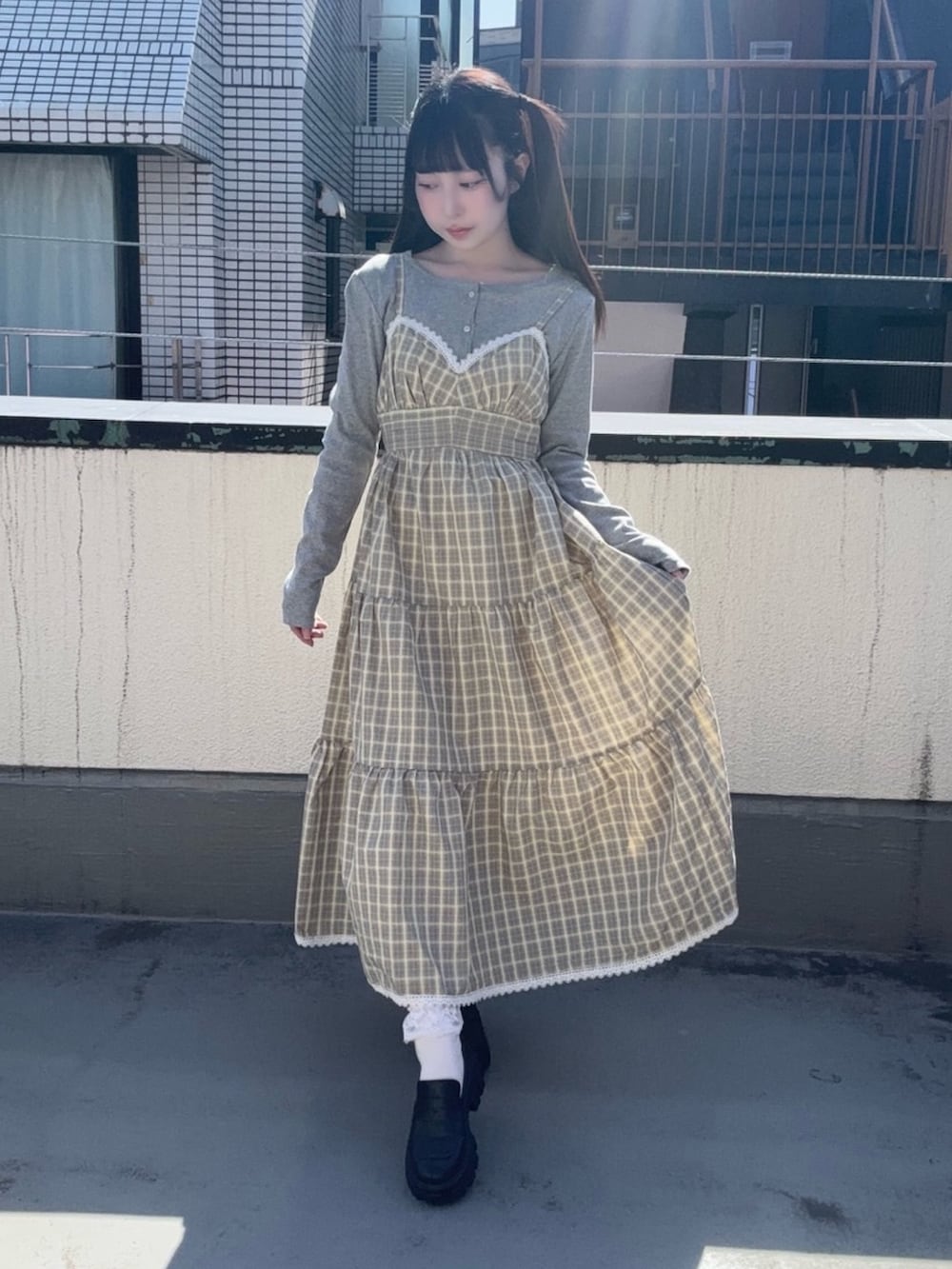 イエロー系のワンピース、グレー系のカーディガン/ボレロを着用したレディースの春コーディネートの2枚目の写真