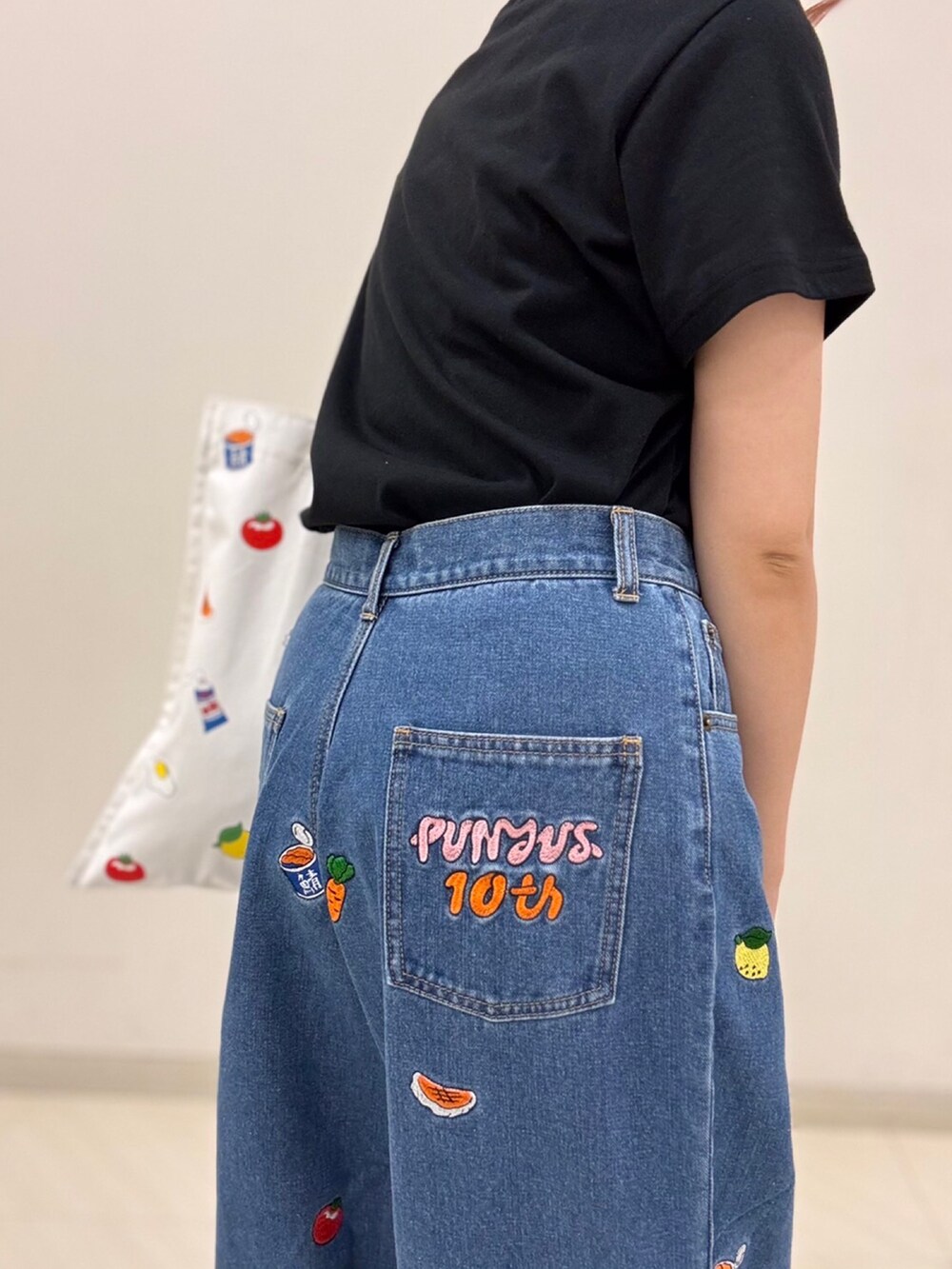 ブラック系のTシャツ/カットソー、ブルー系のデニムパンツ、ホワイト系のトートバッグを着用したレディースの夏コーディネートの2枚目の写真