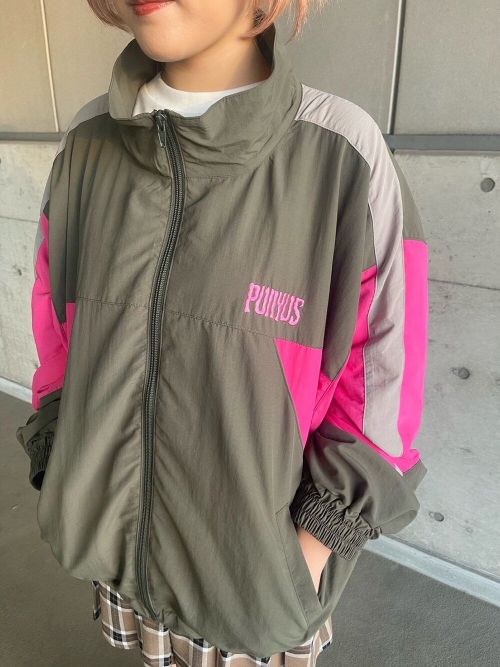 ホワイト系のTシャツ/カットソー、グリーン系のナイロンジャケット、ベージュ系のスカートを着用したレディースの秋コーディネートの3枚目の写真