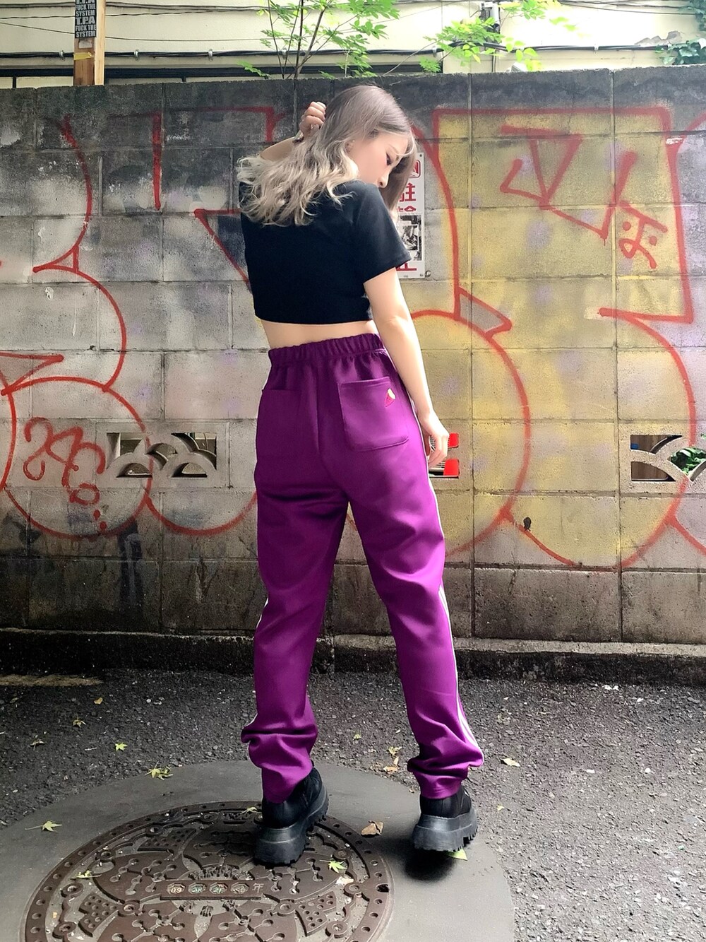 ブラック系のTシャツ/カットソー、パープル系のその他パンツ、ブラック系のブーツを着用したレディースの夏コーディネートの2枚目の写真