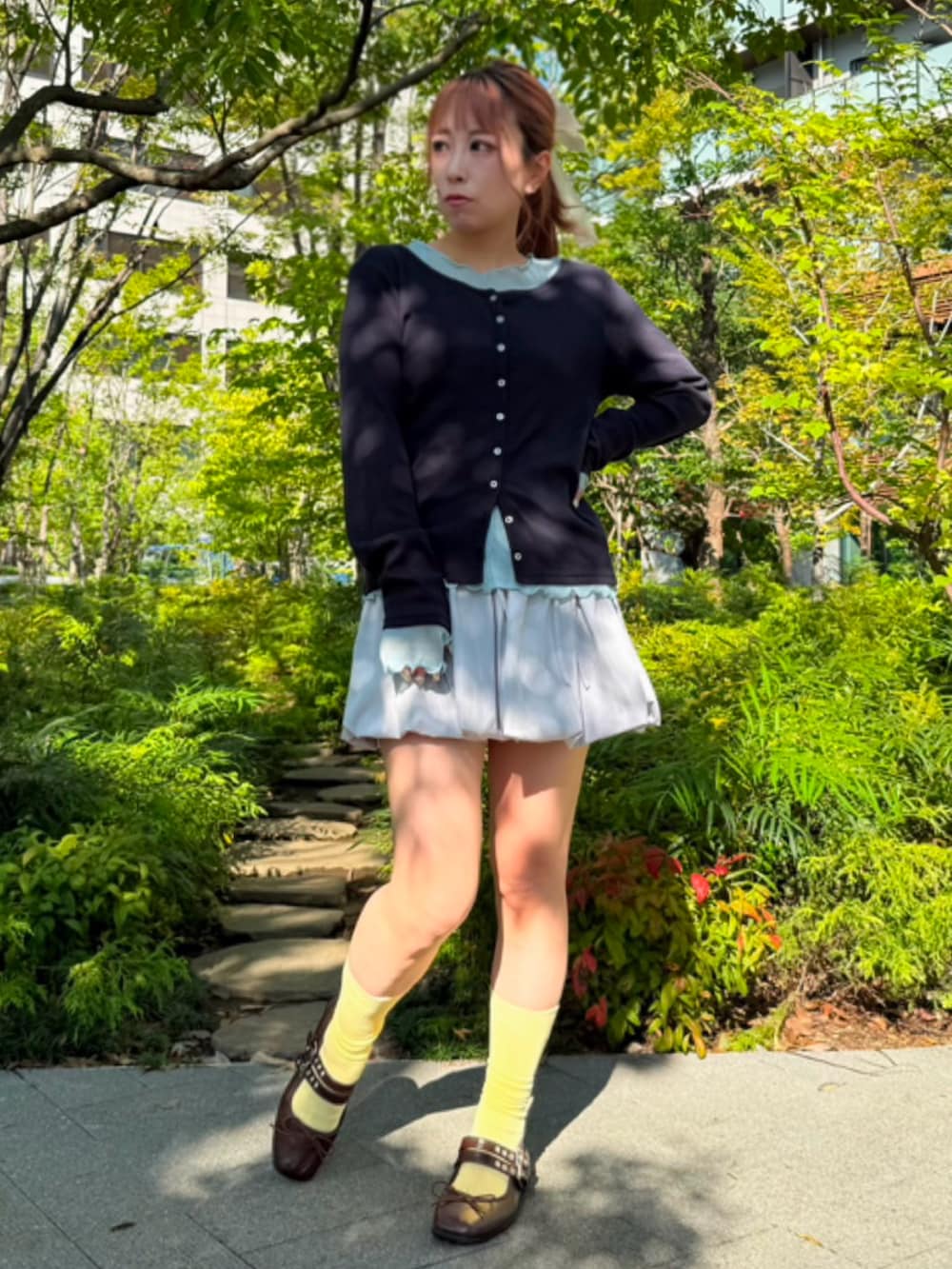 グレー系のスカート、ブルー系のTシャツ/カットソー、ブルー系のカーディガン/ボレロを着用したレディースの秋コーディネートの2枚目の写真