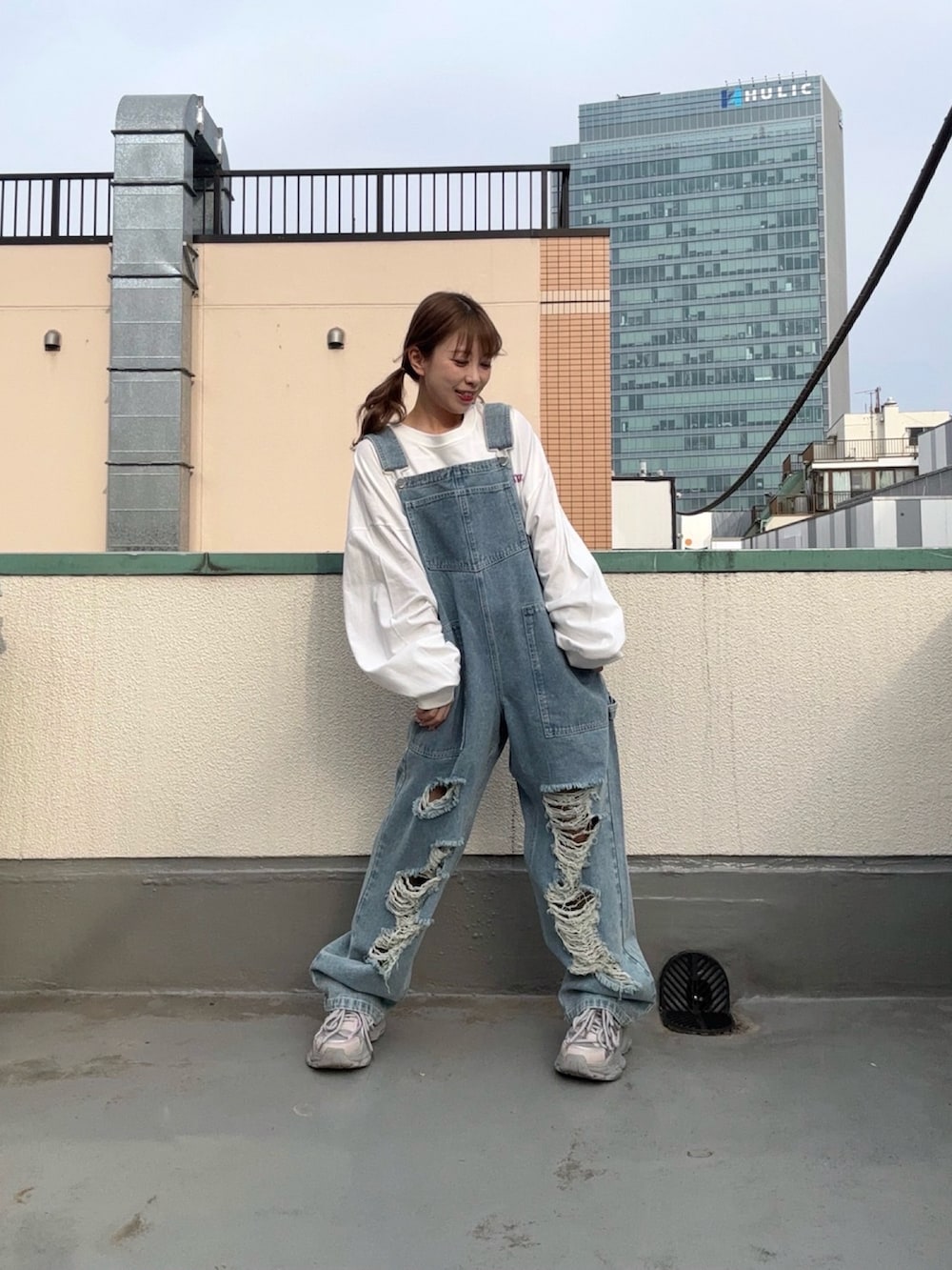 ブルー系のサロペット/オーバーオール、ホワイト系のTシャツ/カットソーを着用したレディースの春コーディネートの3枚目の写真