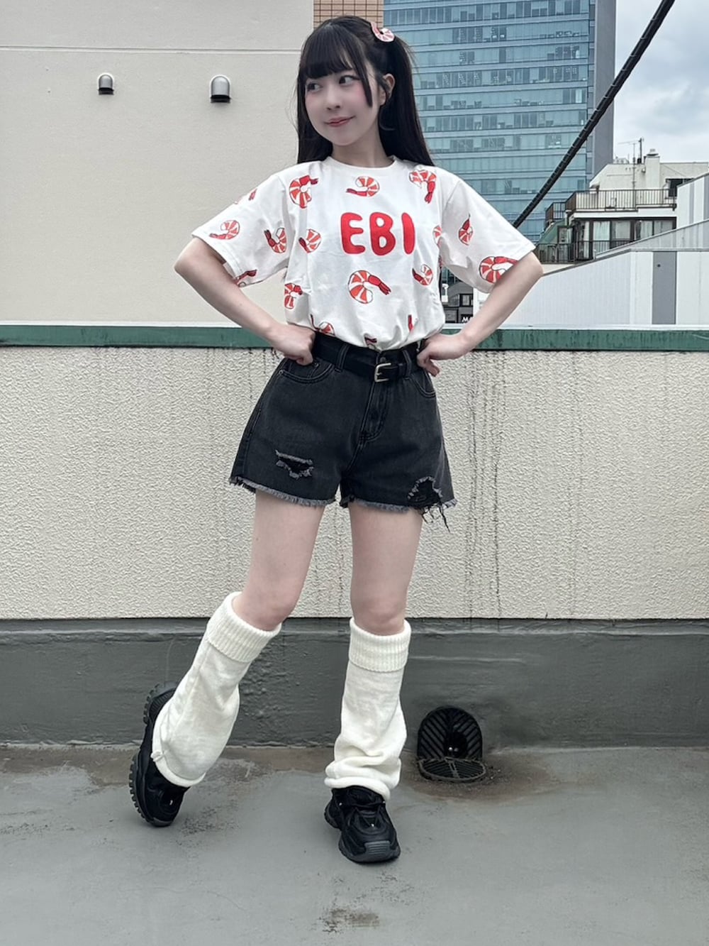ブラック系のデニムパンツ、レッド系のTシャツ/カットソー、ブラック系のベルトを着用したレディースの春コーディネートの3枚目の写真