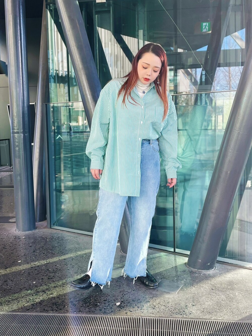 グリーン系のシャツ/ブラウス、ブルー系のデニムパンツ、ホワイト系のTシャツ/カットソーを着用したレディースの冬コーディネートの3枚目の写真