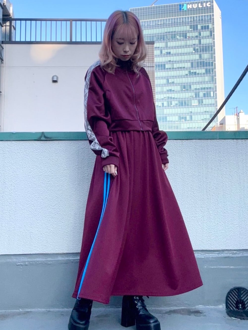 レッド系のジャージ、レッド系のスカートを着用したレディースの秋コーディネートの2枚目の写真