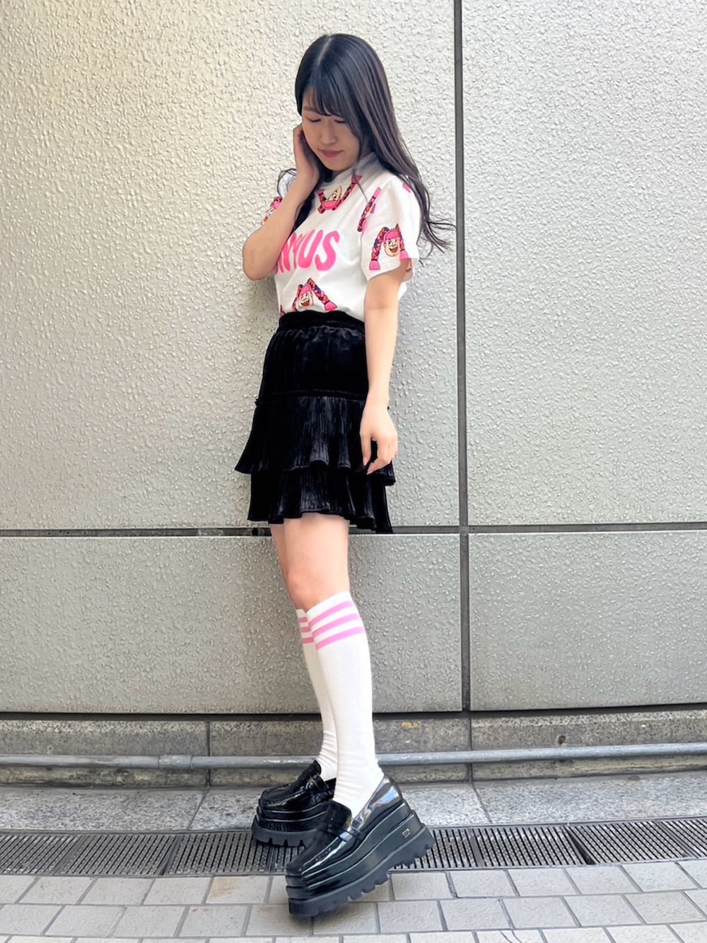 ブラック系のスカート、ホワイト系のTシャツ/カットソーを着用したレディースの春コーディネートの3枚目の写真