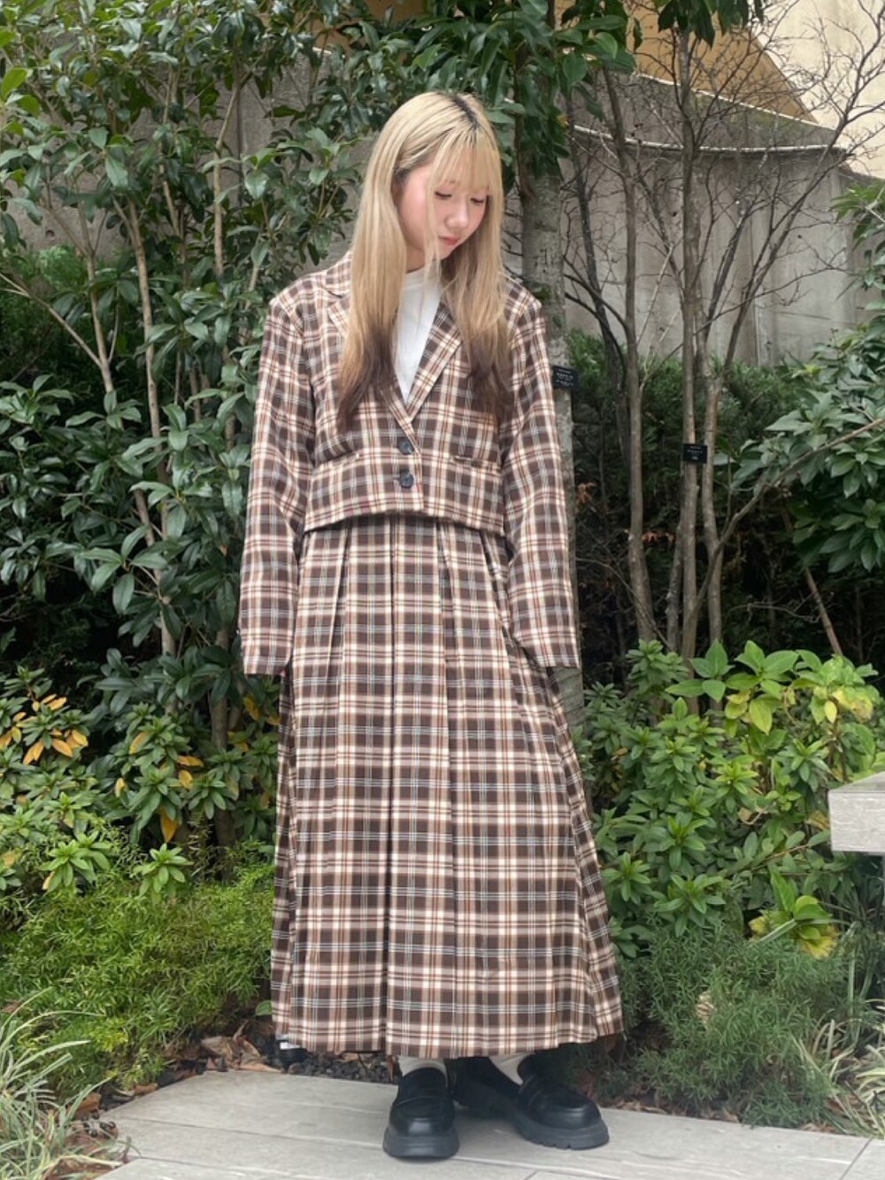 ブラウン系のスカート、ブラウン系のテーラードジャケット、ホワイト系のTシャツ/カットソーを着用したレディースの冬コーディネートの2枚目の写真
