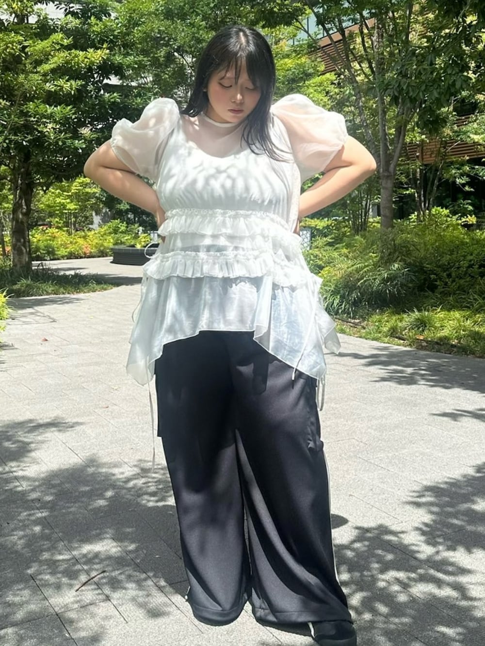 ブラック系のカーゴパンツ、ホワイト系のワンピース、ホワイト系のキャミソールを着用したレディースの夏コーディネートの2枚目の写真