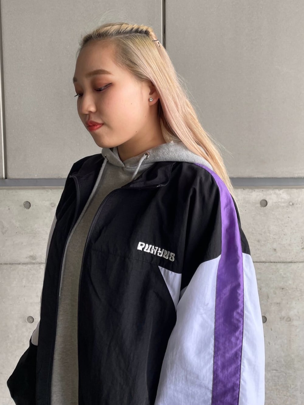 ブラック系のナイロンジャケット、グレー系のパーカー、パープル系のその他パンツを着用したレディースの冬コーディネートの2枚目の写真