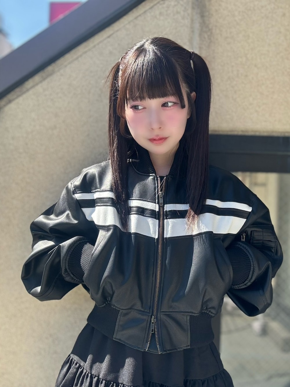 ブラック系のスカート、ブラック系のブルゾンを着用したレディースの春コーディネートの5枚目の写真