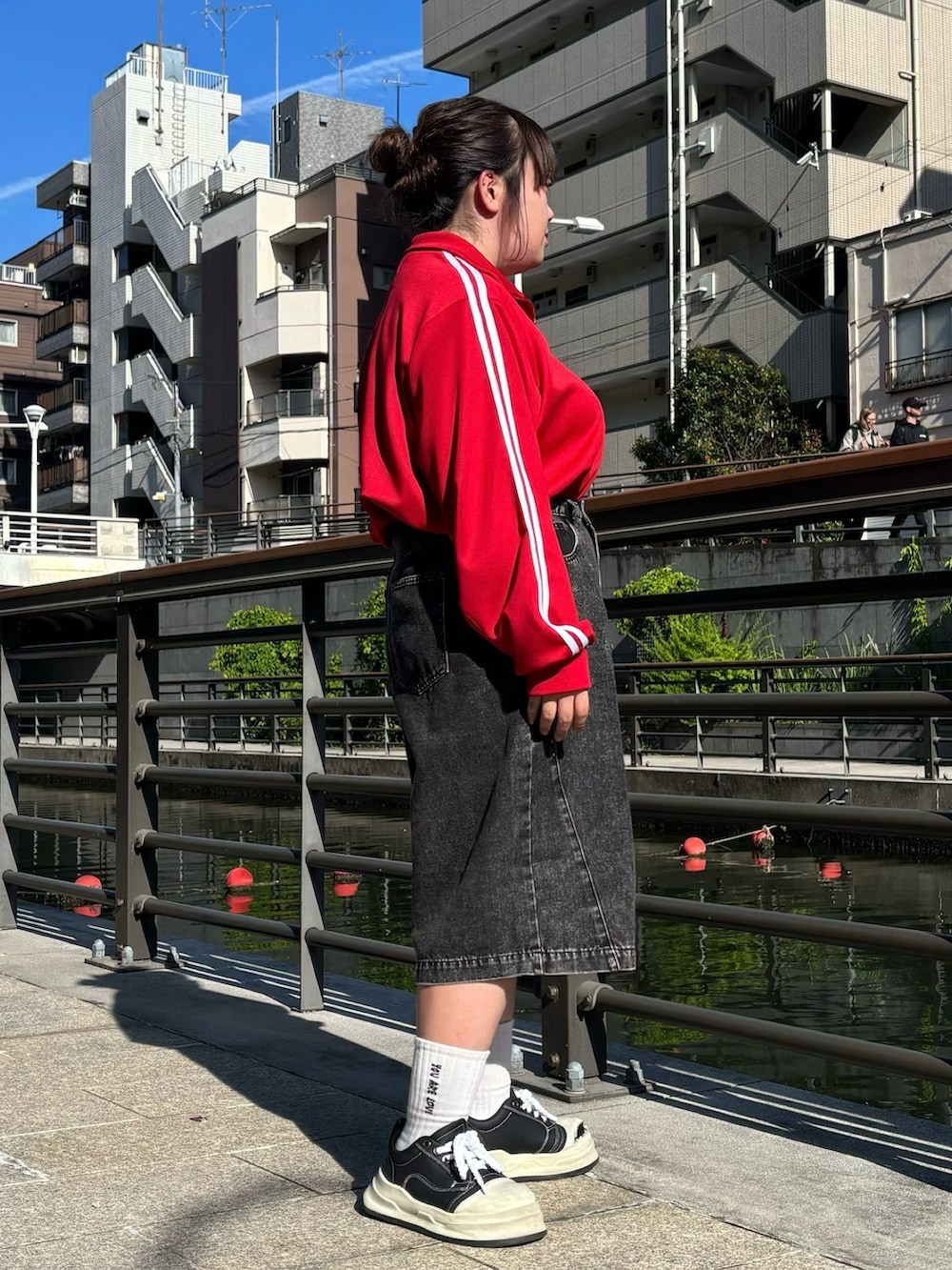ブラック系のデニムパンツ、レッド系のジャージを着用したレディースの夏コーディネートの4枚目の写真