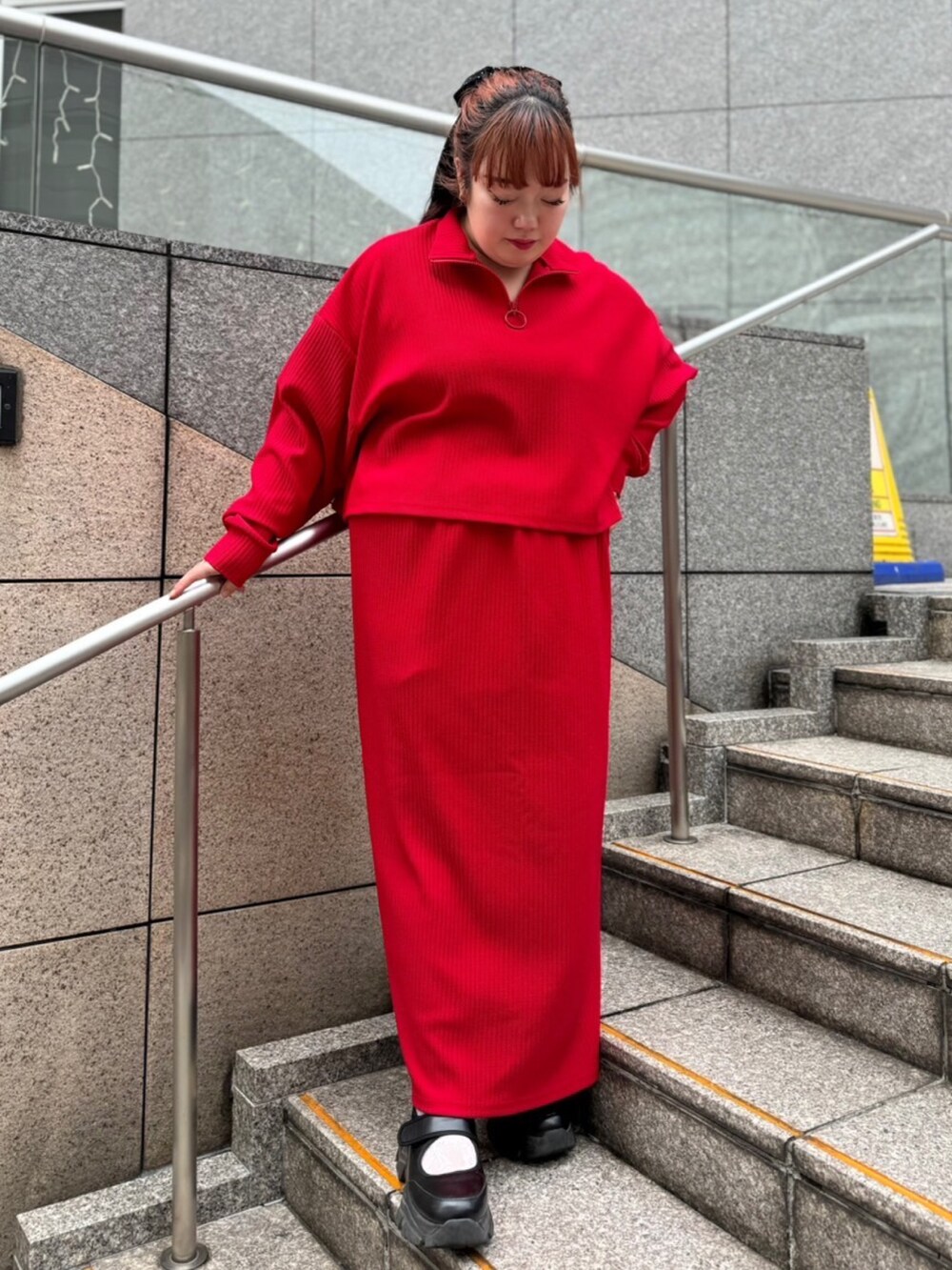 レッド系のスウェット、レッド系のスカートを着用したレディースの秋コーディネートの2枚目の写真