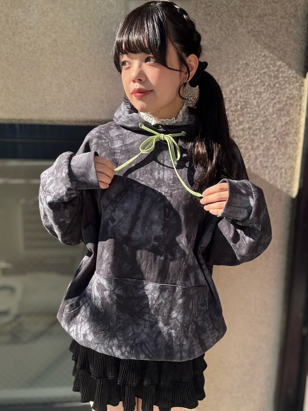 ブラック系のパーカー、ブラック系のスカートを着用したレディースの冬コーディネートの2枚目の写真