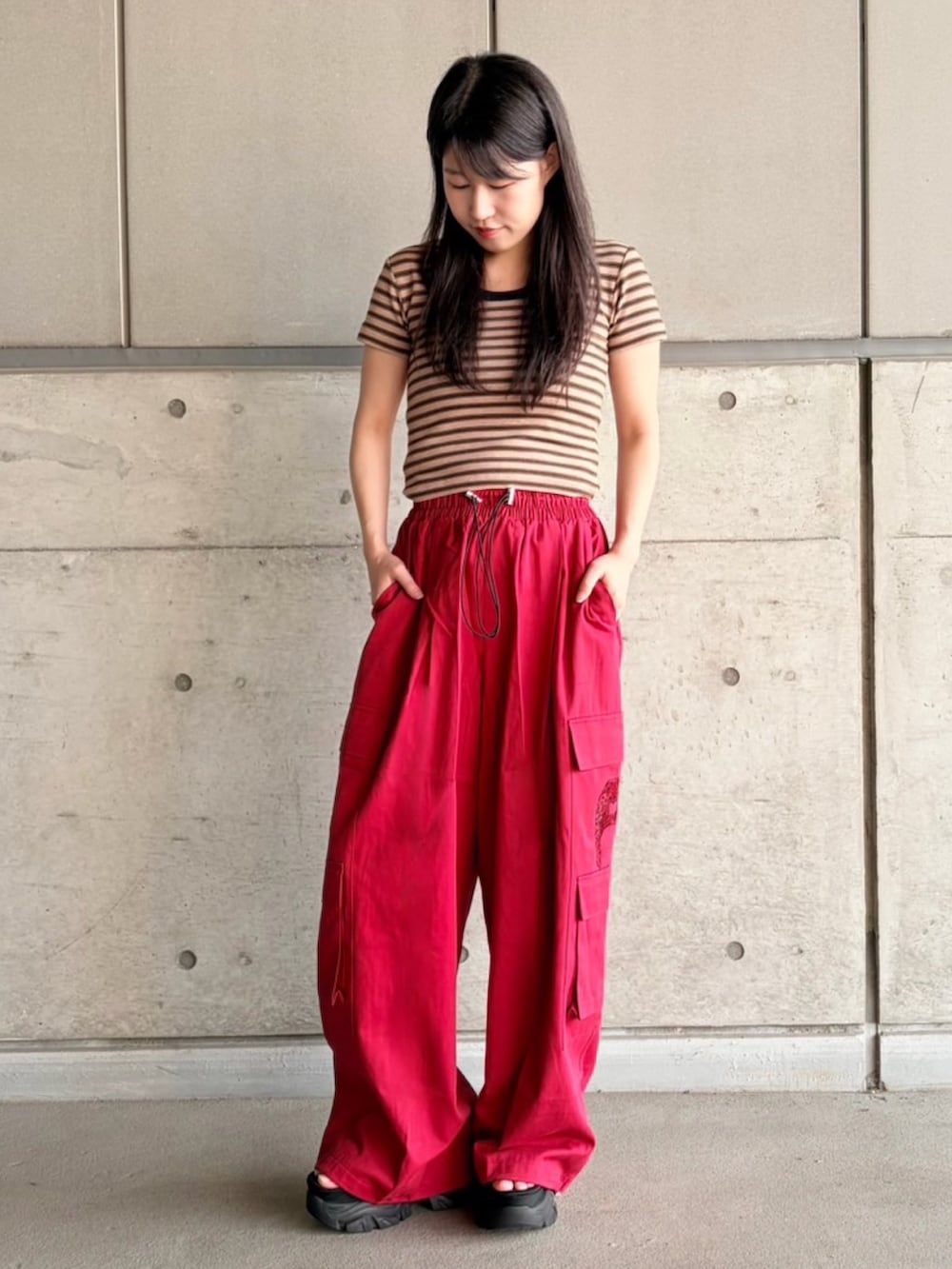 レッド系のカーゴパンツ、ブラウン系のTシャツ/カットソーを着用したレディースの夏コーディネートの2枚目の写真