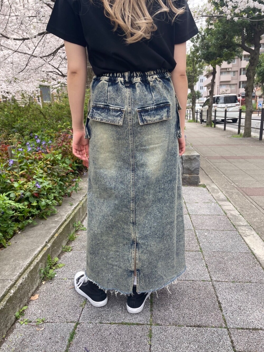 ブラック系のTシャツ/カットソー、ブルー系のデニムスカートを着用したレディースの春コーディネートの5枚目の写真