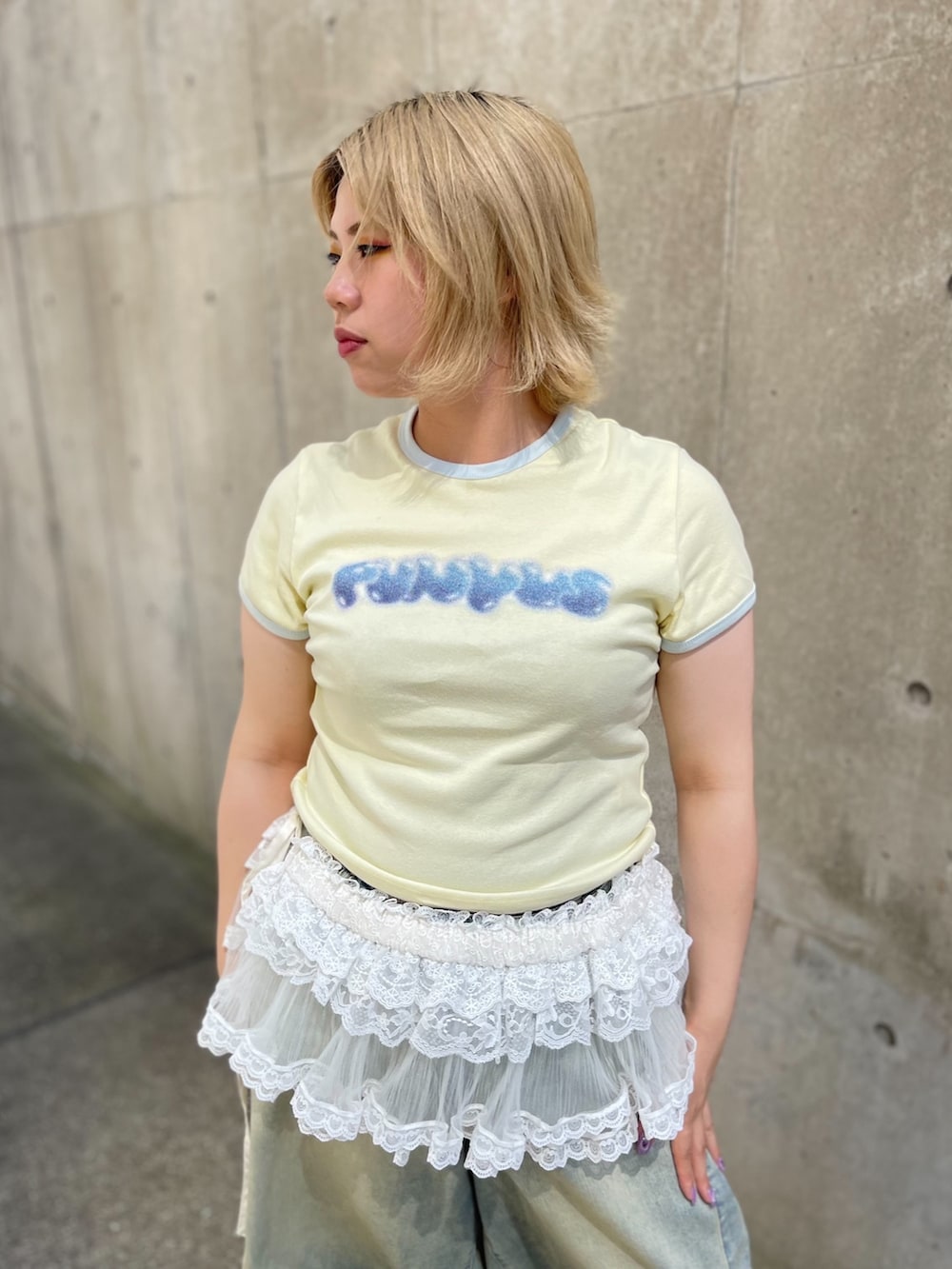 ブルー系のデニムパンツ、ホワイト系のスカート、イエロー系のTシャツ/カットソーを着用したレディースの夏コーディネートの5枚目の写真