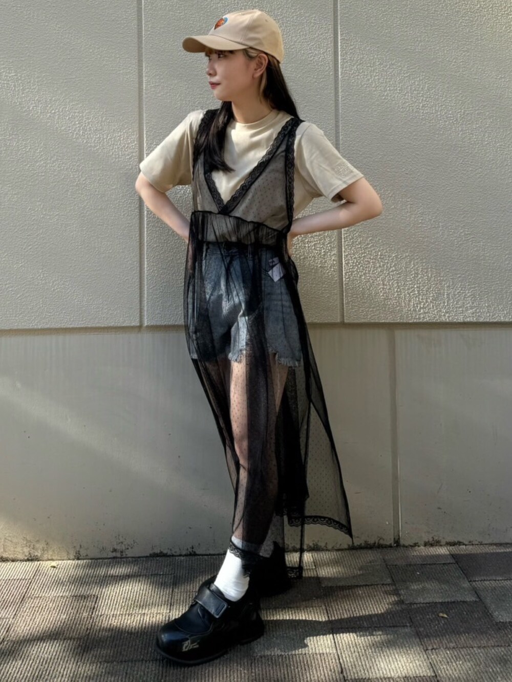 ブルー系のデニムパンツ、ブラック系のワンピース、ベージュ系のTシャツ/カットソーを着用したレディースの夏コーディネートの2枚目の写真