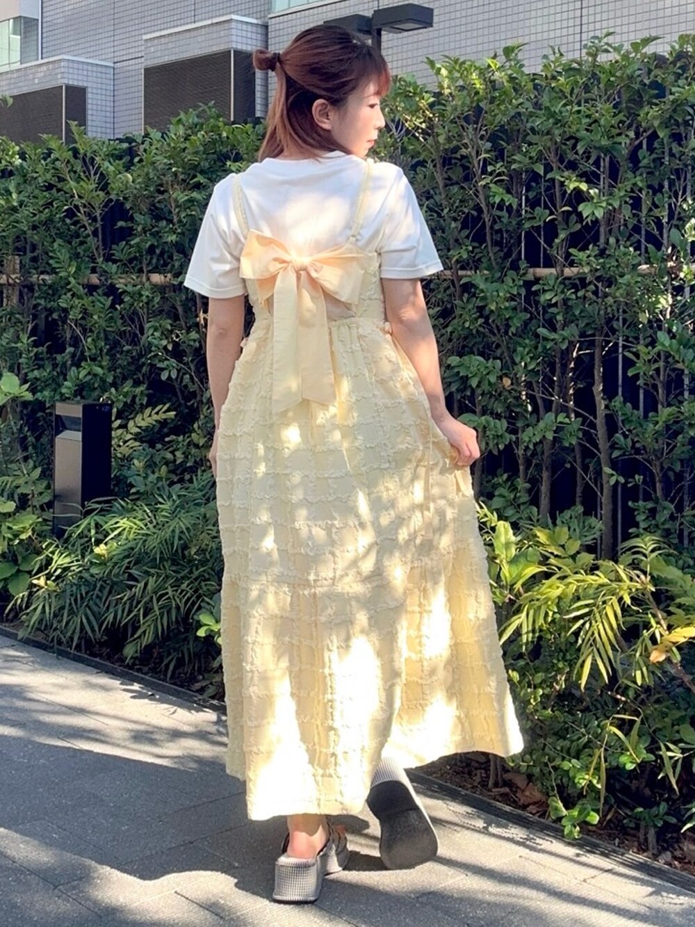 イエロー系のワンピース、ホワイト系のTシャツ/カットソーを着用したレディースの夏コーディネートの4枚目の写真