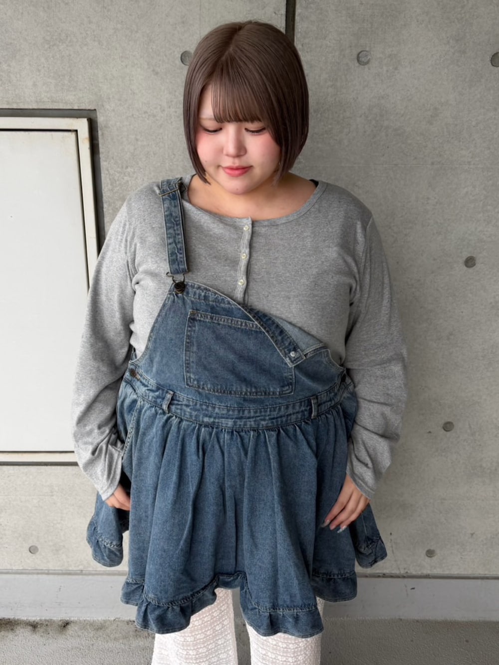 ホワイト系のその他パンツ、ブルー系のジャンパースカート、グレー系のカーディガン/ボレロを着用したレディースの秋コーディネートの6枚目の写真