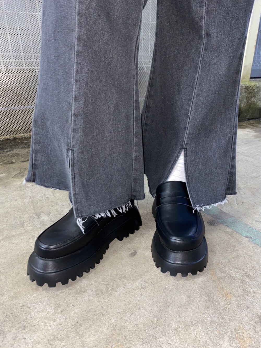 ブラック系のデニムパンツ、ブラック系のローファー、ホワイト系のベストを着用したレディースの春コーディネートの3枚目の写真