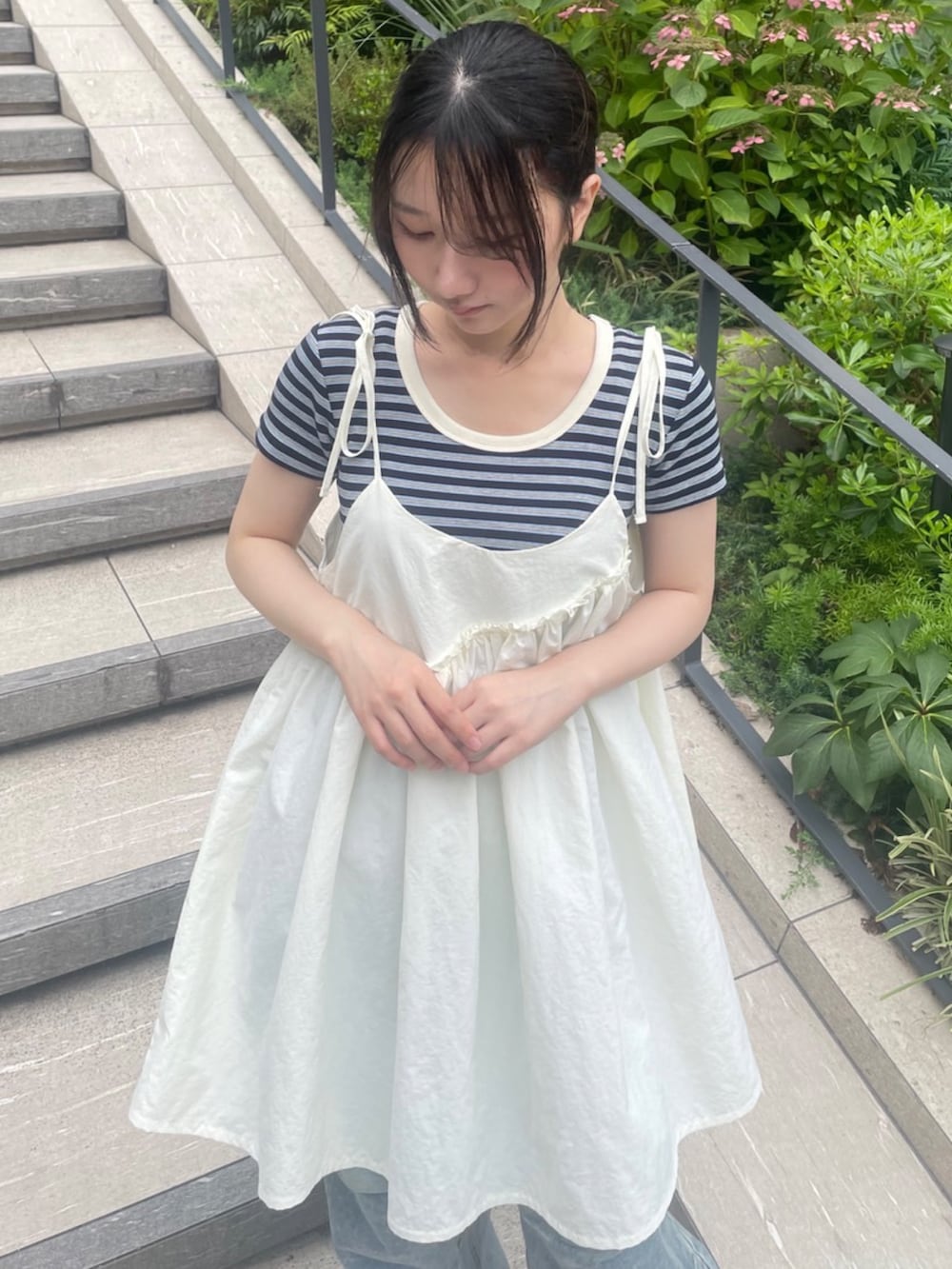 ブルー系のデニムパンツ、ホワイト系のワンピース、ブルー系のTシャツ/カットソーを着用したレディースの夏コーディネートの2枚目の写真