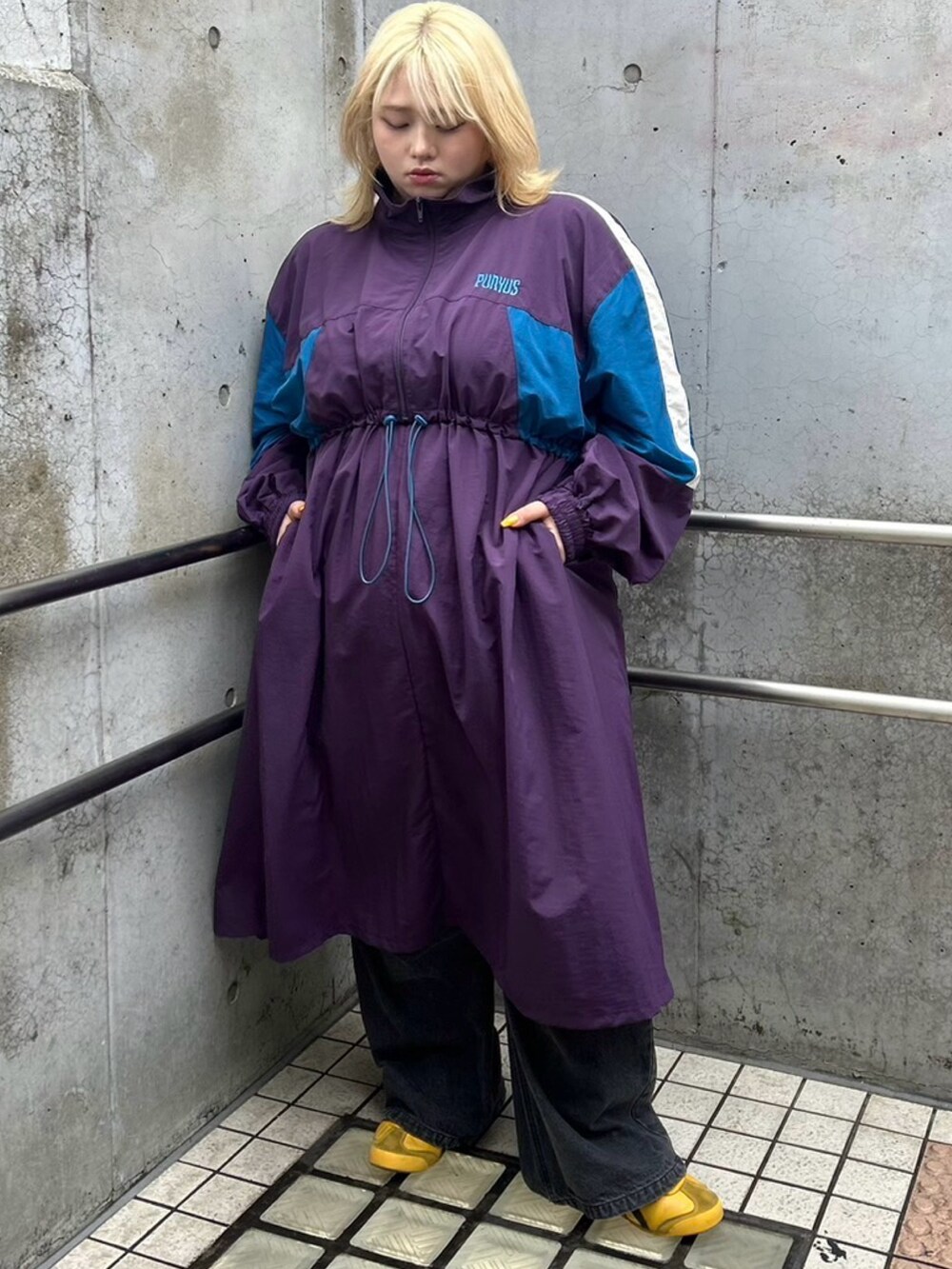 パープル系のワンピース、ブルー系のその他パンツを着用したレディースの秋コーディネートの2枚目の写真