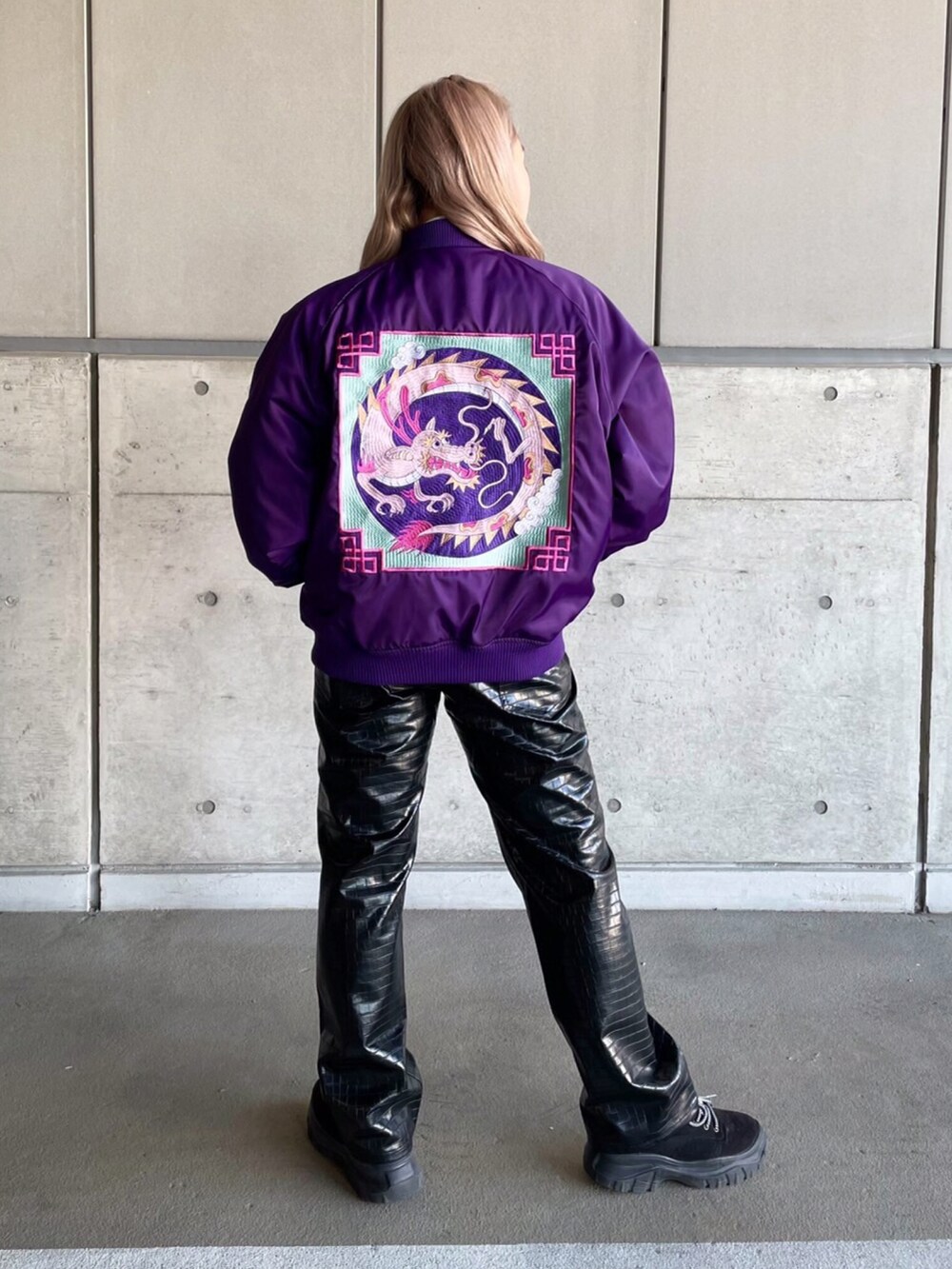 ホワイト系のTシャツ/カットソー、パープル系のブルゾン、ブラック系のその他パンツを着用したレディースの冬コーディネートの2枚目の写真