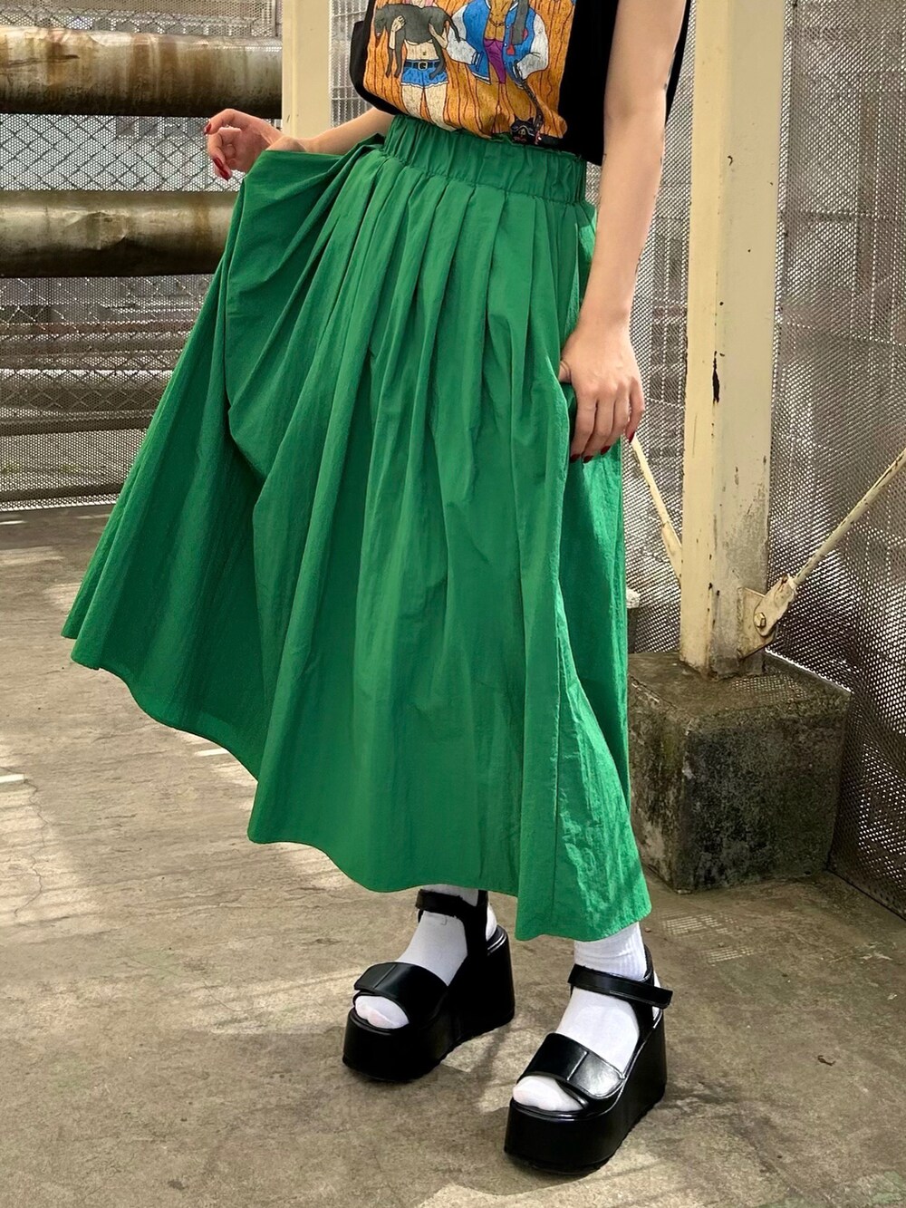 ブラック系のサンダル、ブラック系のTシャツ/カットソー、グリーン系のスカートを着用したレディースの夏コーディネートの4枚目の写真