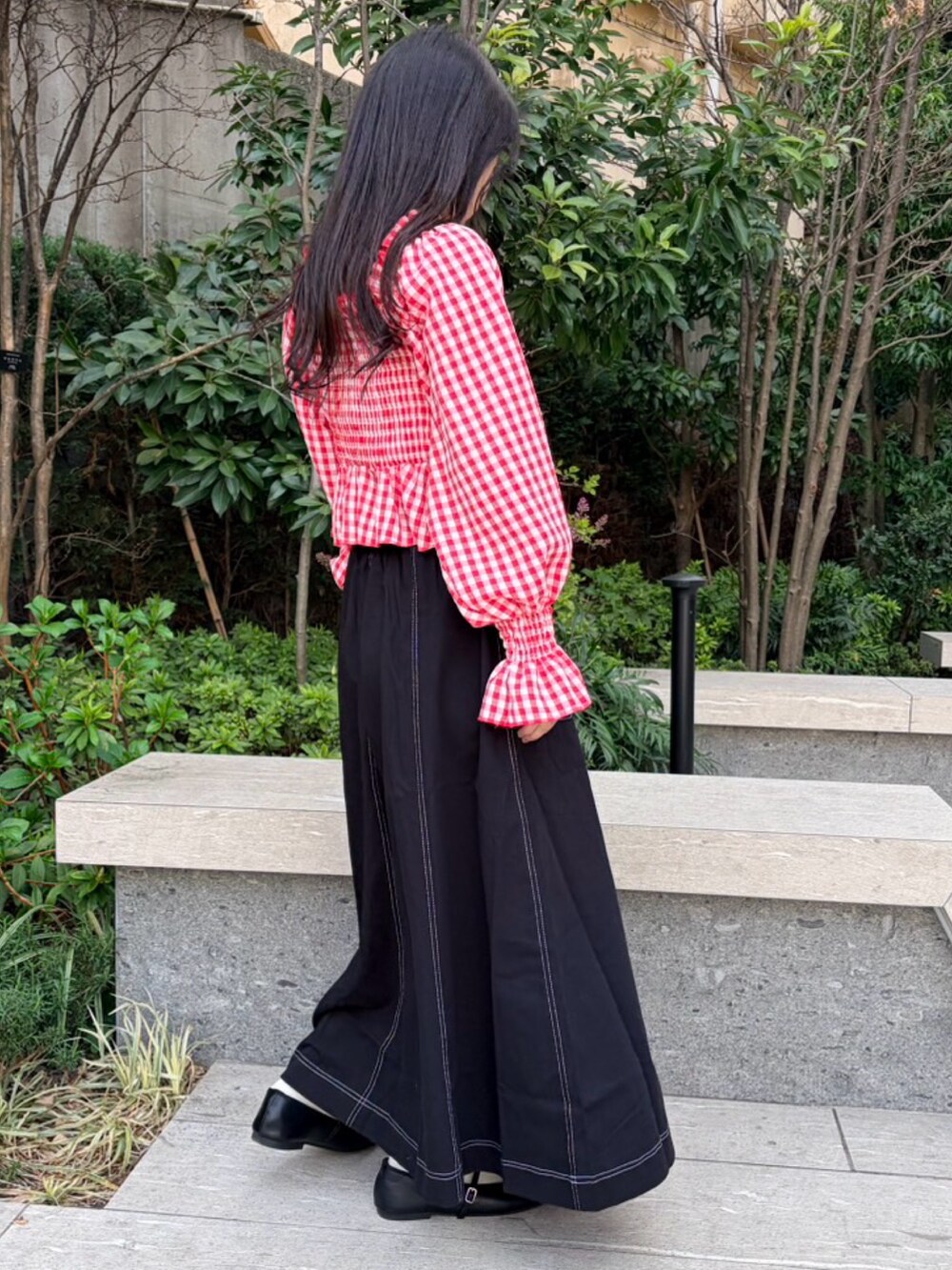 ブラック系のスカート、レッド系のシャツ/ブラウスを着用したレディースの春コーディネートの3枚目の写真
