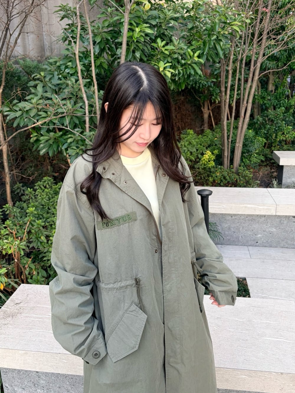 イエロー系のTシャツ/カットソー、グリーン系のモッズコート、グレー系のスカートを着用したレディースの冬コーディネートの6枚目の写真