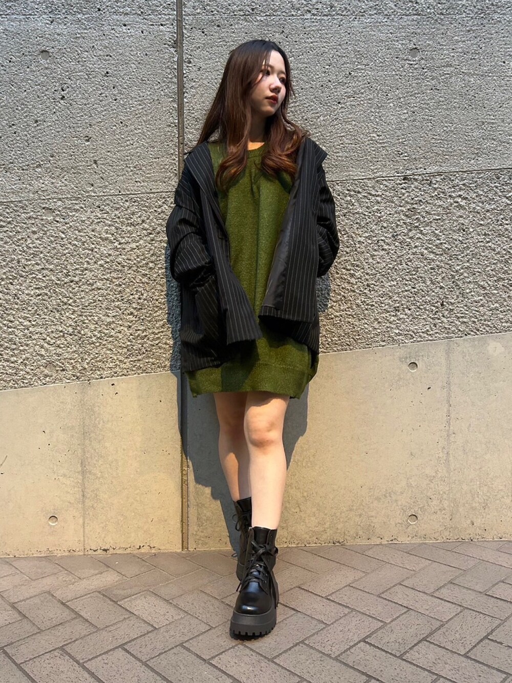 グリーン系のニット/セーター、グレー系のテーラードジャケットを着用したレディースの秋コーディネートの4枚目の写真