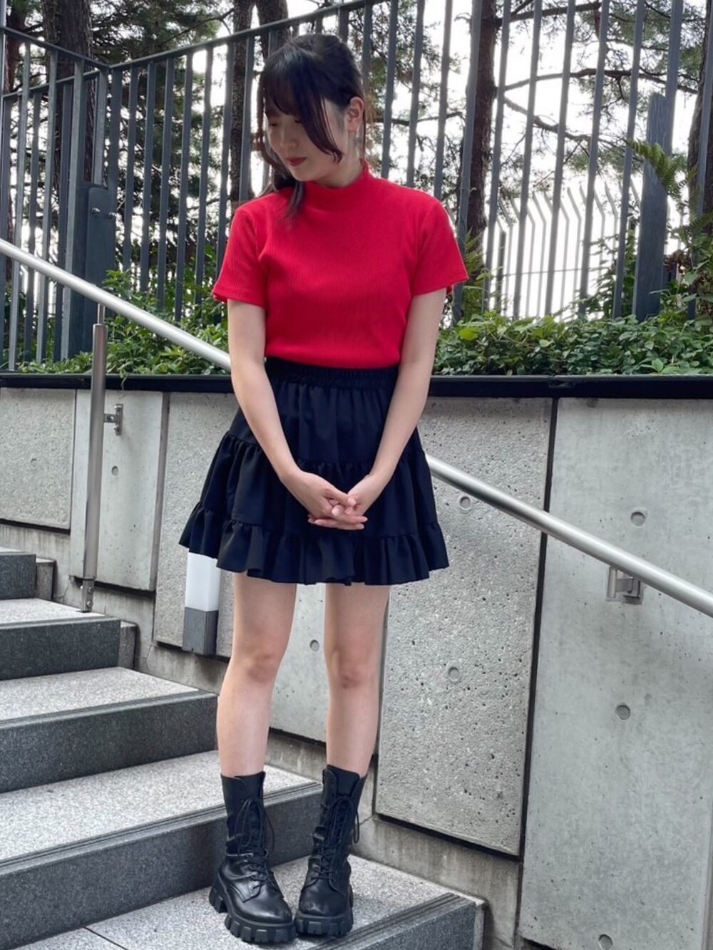 レッド系のTシャツ/カットソー、ブラック系のスカートを着用したレディースの秋コーディネートの2枚目の写真