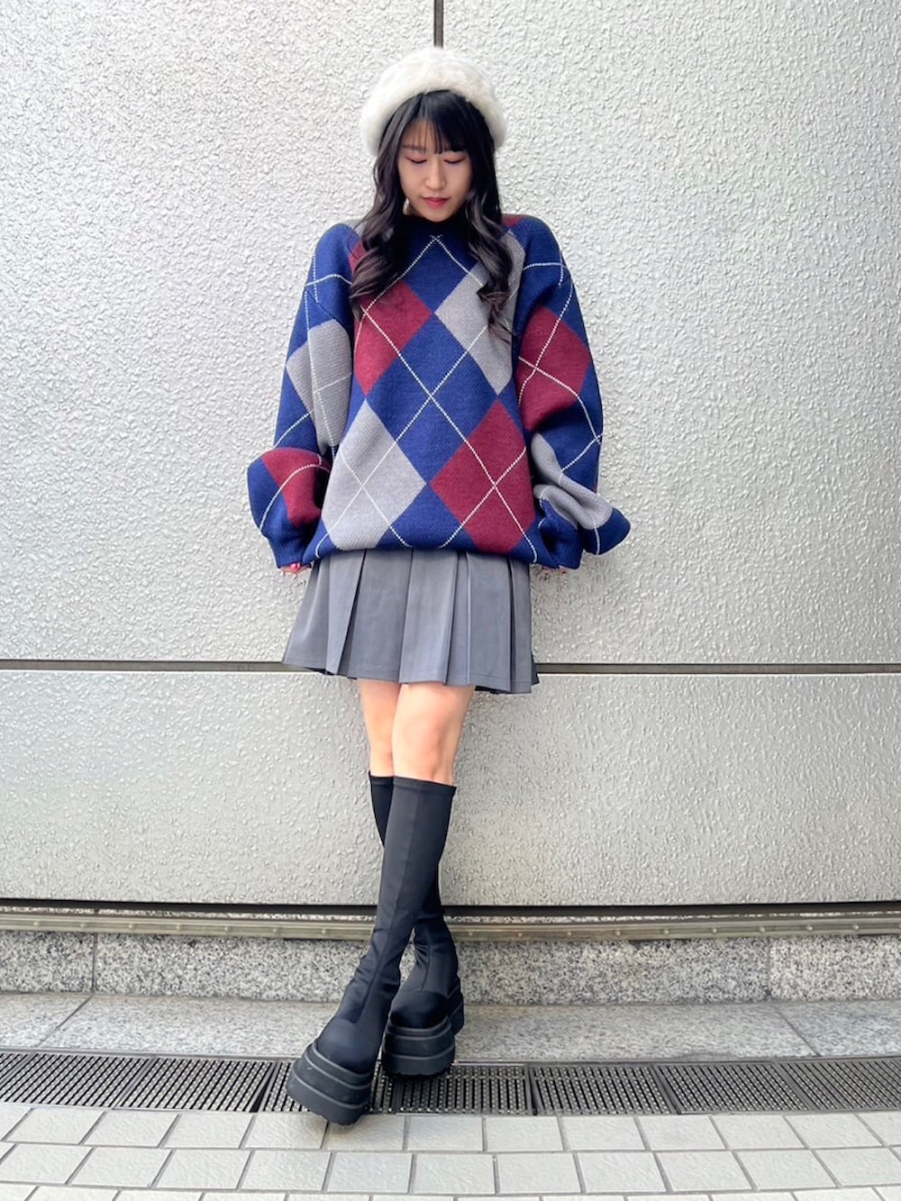 ブルー系のニット/セーター、グレー系のスカート、ホワイト系のハンチング/ベレー帽を着用したレディースの冬コーディネートの2枚目の写真