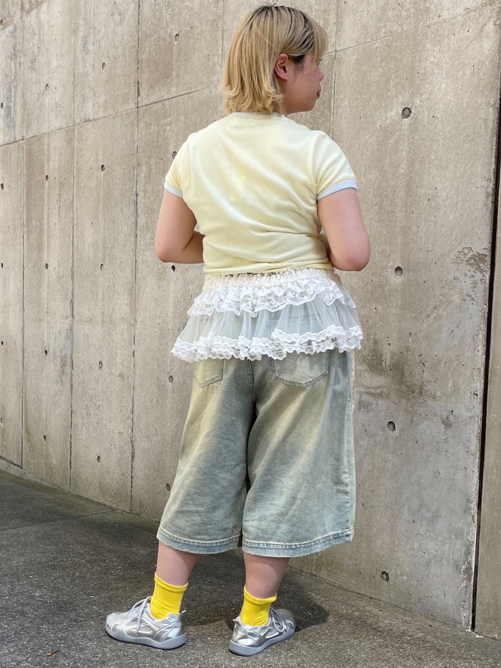 ブルー系のデニムパンツ、ホワイト系のスカート、イエロー系のTシャツ/カットソーを着用したレディースの夏コーディネートの9枚目の写真