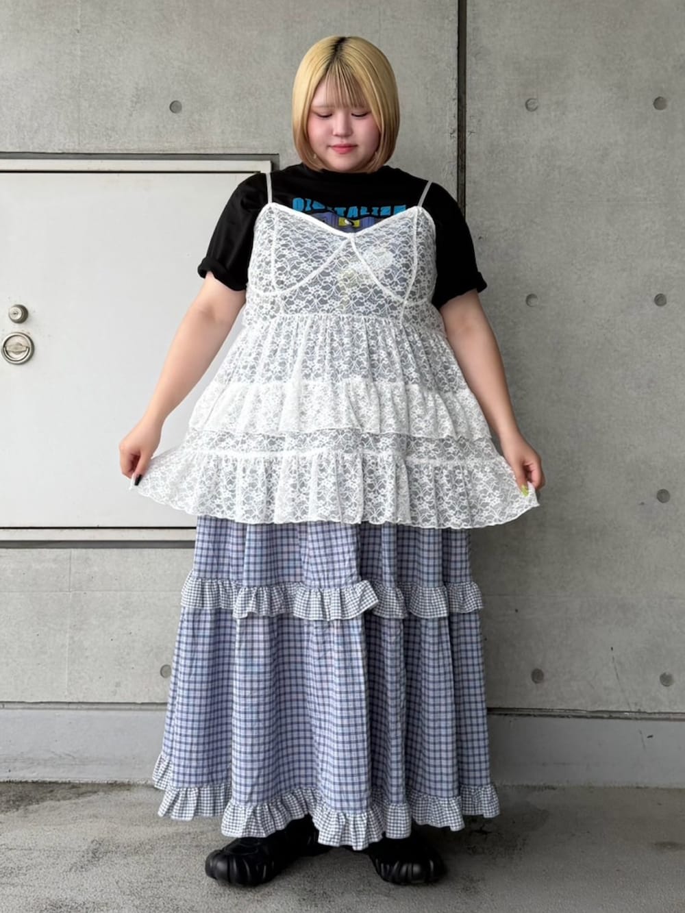 ブルー系のスカート、ホワイト系のチュニック、ブラック系のTシャツ/カットソーを着用したレディースの夏コーディネートの2枚目の写真