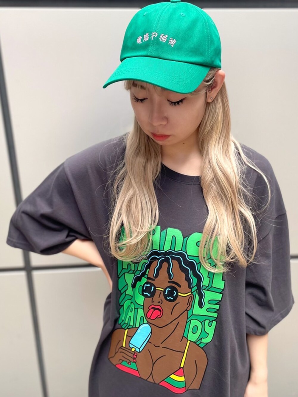 ブラック系のTシャツ/カットソー、グリーン系のキャップを着用したレディースの夏コーディネートの2枚目の写真