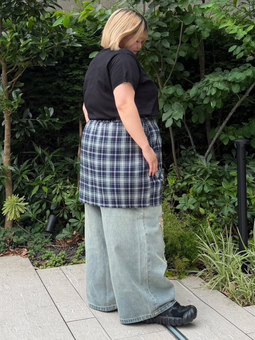 ブルー系のデニムパンツ、ブルー系のスカート、ブラック系のニット/セーターを着用したレディースの夏コーディネートの4枚目の写真