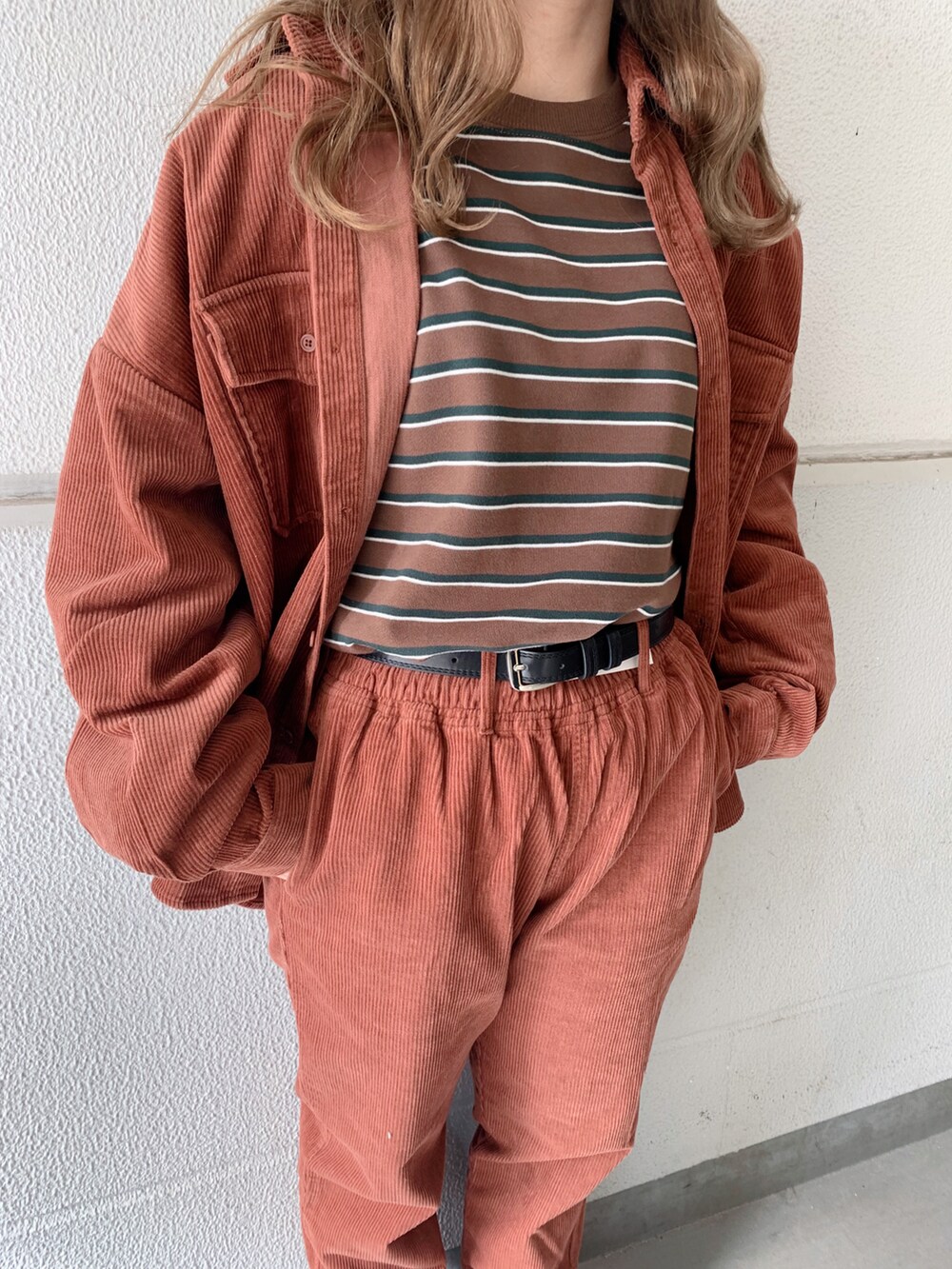 ブラウン系のシャツ/ブラウス、ブラウン系のスラックス、ブラック系のスニーカーを着用したレディースの秋コーディネートの2枚目の写真