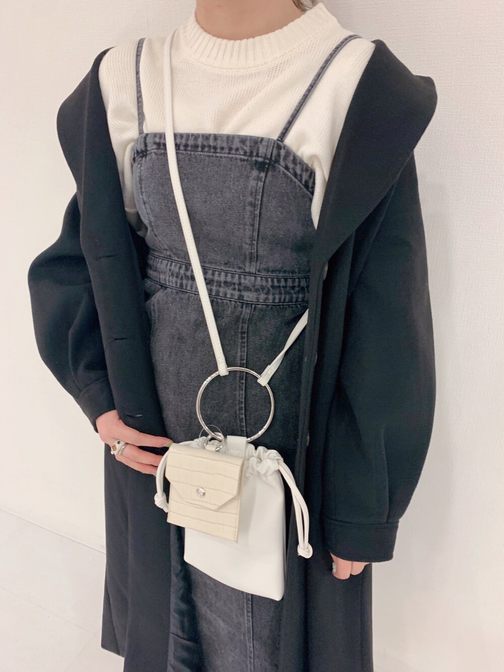 ホワイト系のニット/セーター、ブラック系のワンピース、ホワイト系のショルダーバッグを着用したレディースの秋コーディネートの2枚目の写真