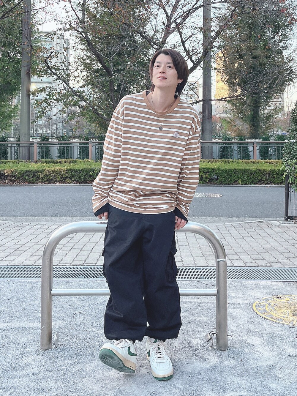 ベージュ系のスニーカー、ブラック系のカーゴパンツ、ベージュ系のTシャツ/カットソーを着用したメンズの冬コーディネートの2枚目の写真