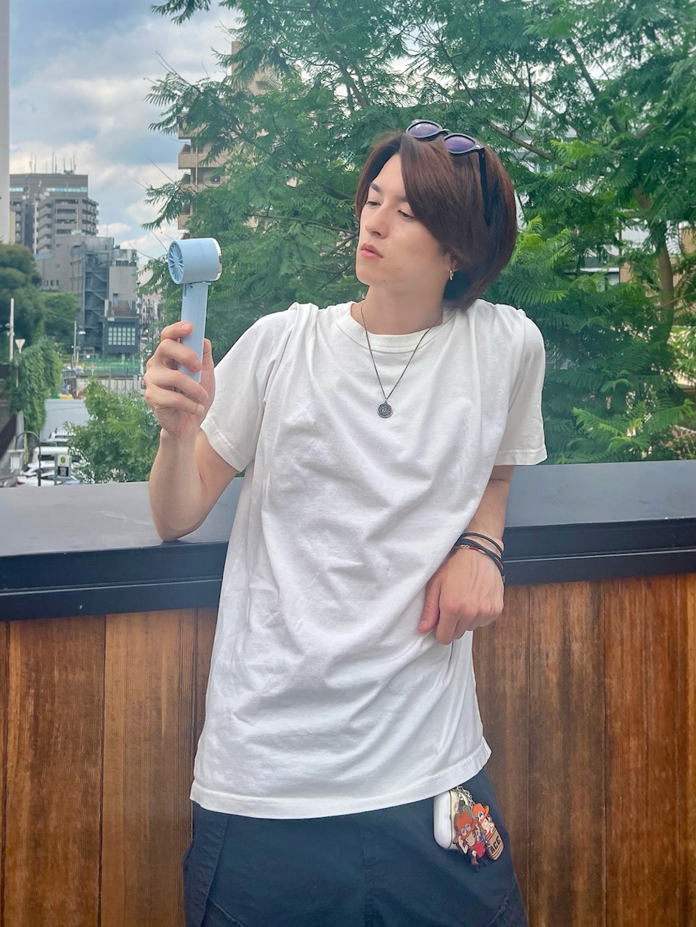 ベージュ系のスニーカー、ブラック系のカーゴパンツ、ホワイト系のTシャツ/カットソーを着用したメンズの夏コーディネートの2枚目の写真