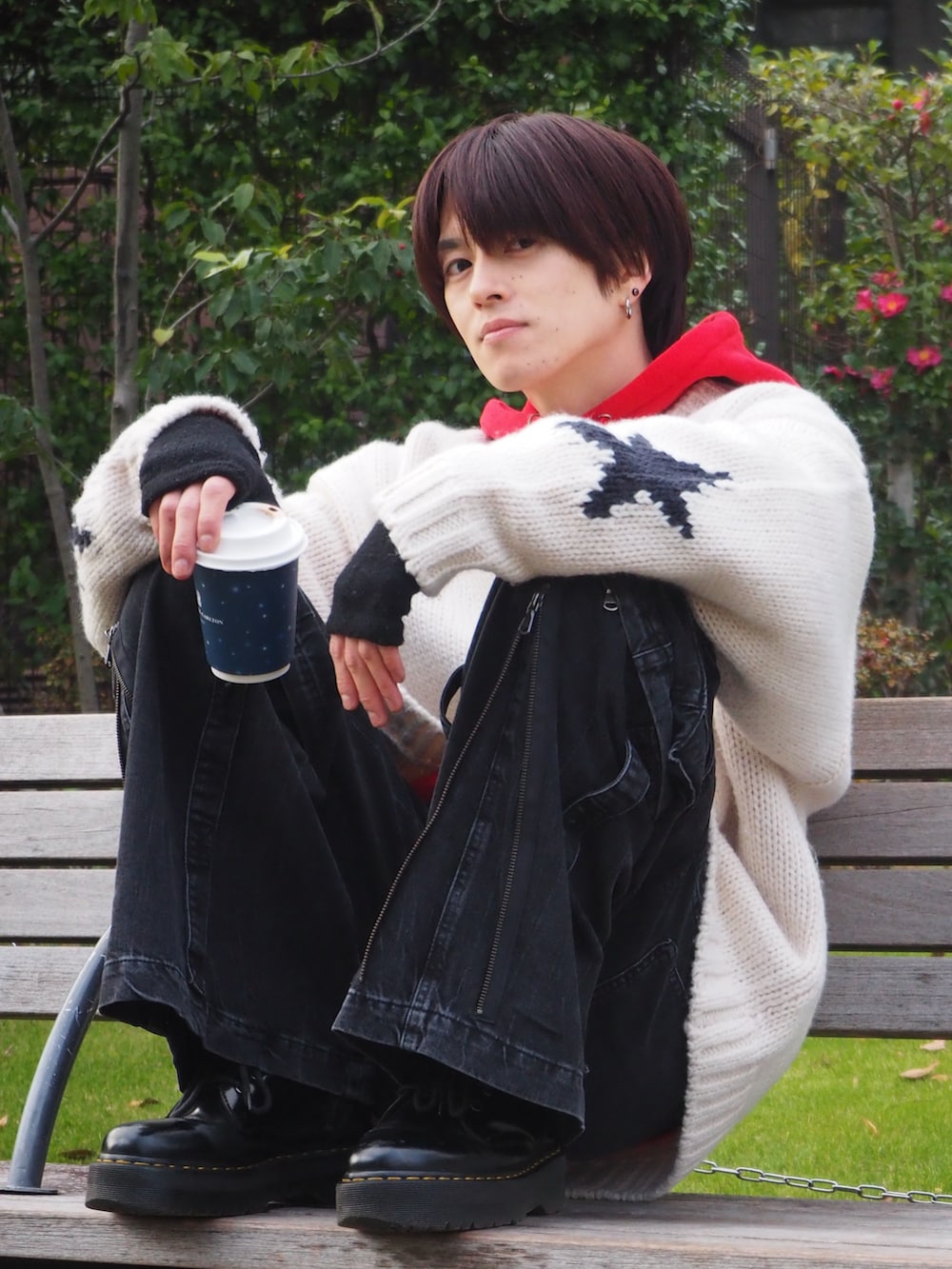 ブラック系のブーツ、グレー系のデニムパンツ、ホワイト系のニット/セーターを着用したメンズの冬コーディネートの2枚目の写真